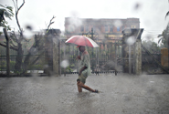  Photo by IRIN. Resident of Myanmar capital, Yangon, threads through floodwaters during a rainpour. June 4, 2008.