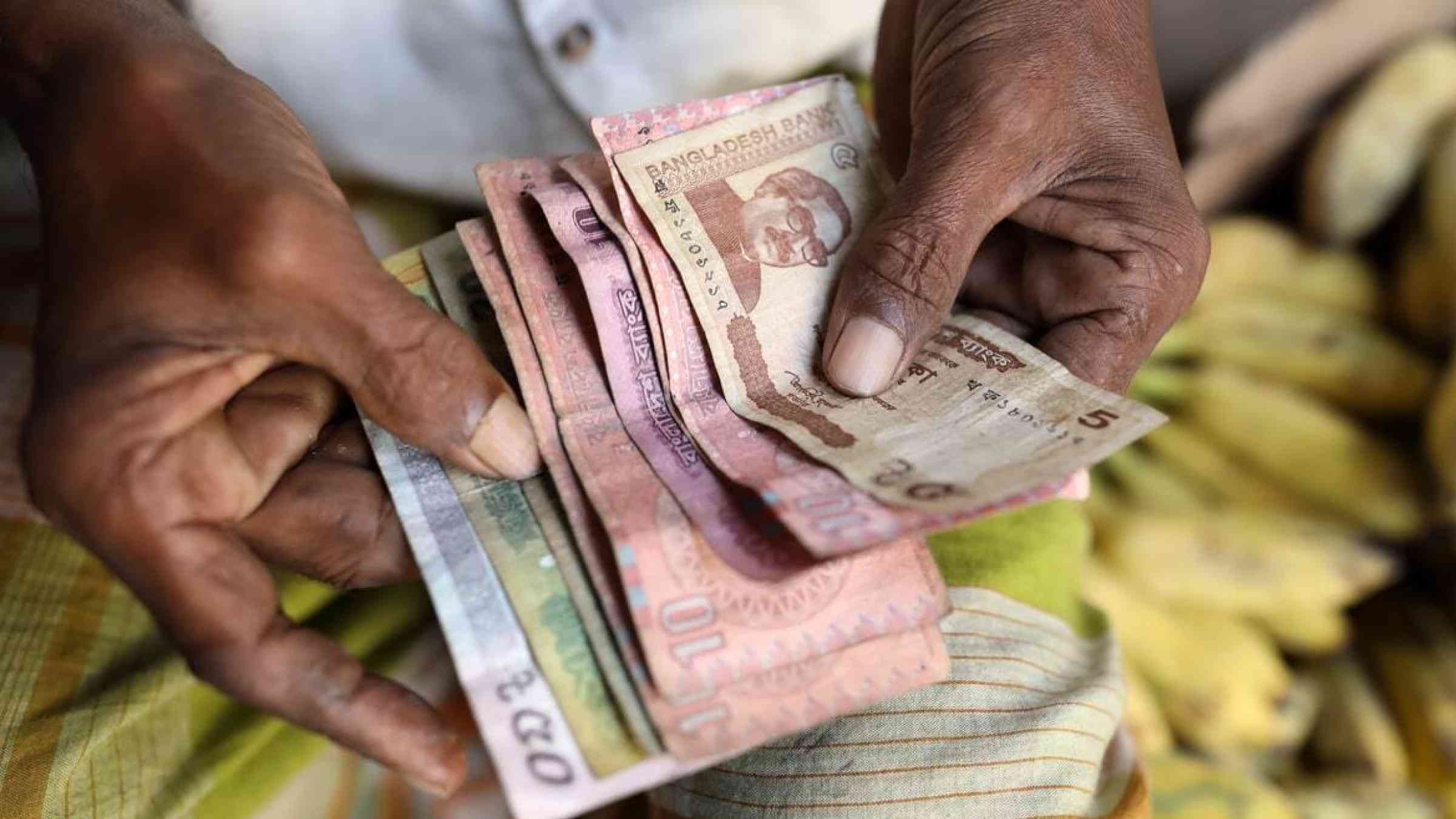 A Bangladeshi man counts money on hand
