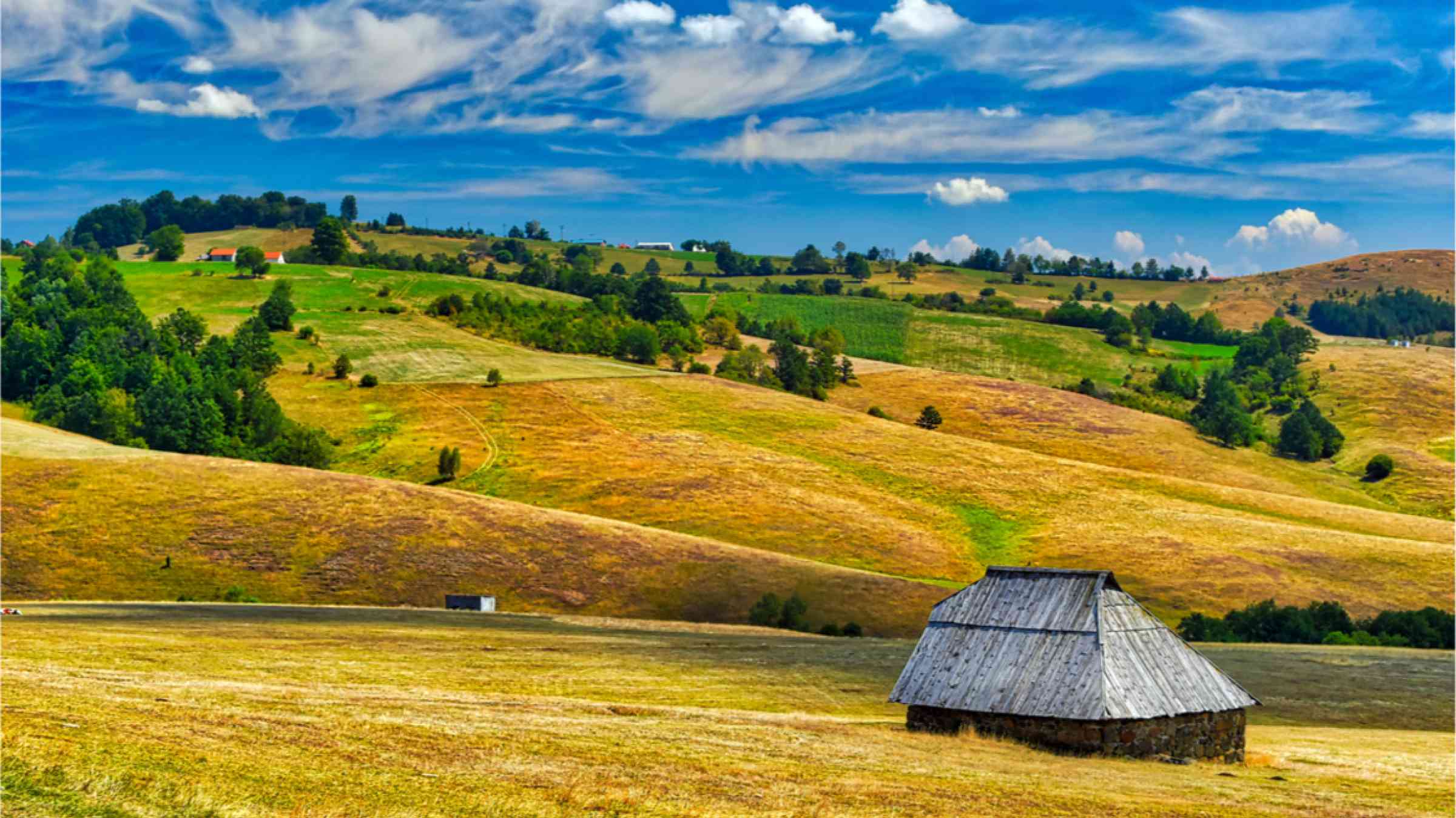 A farm house on hilly farm land in Serbia.