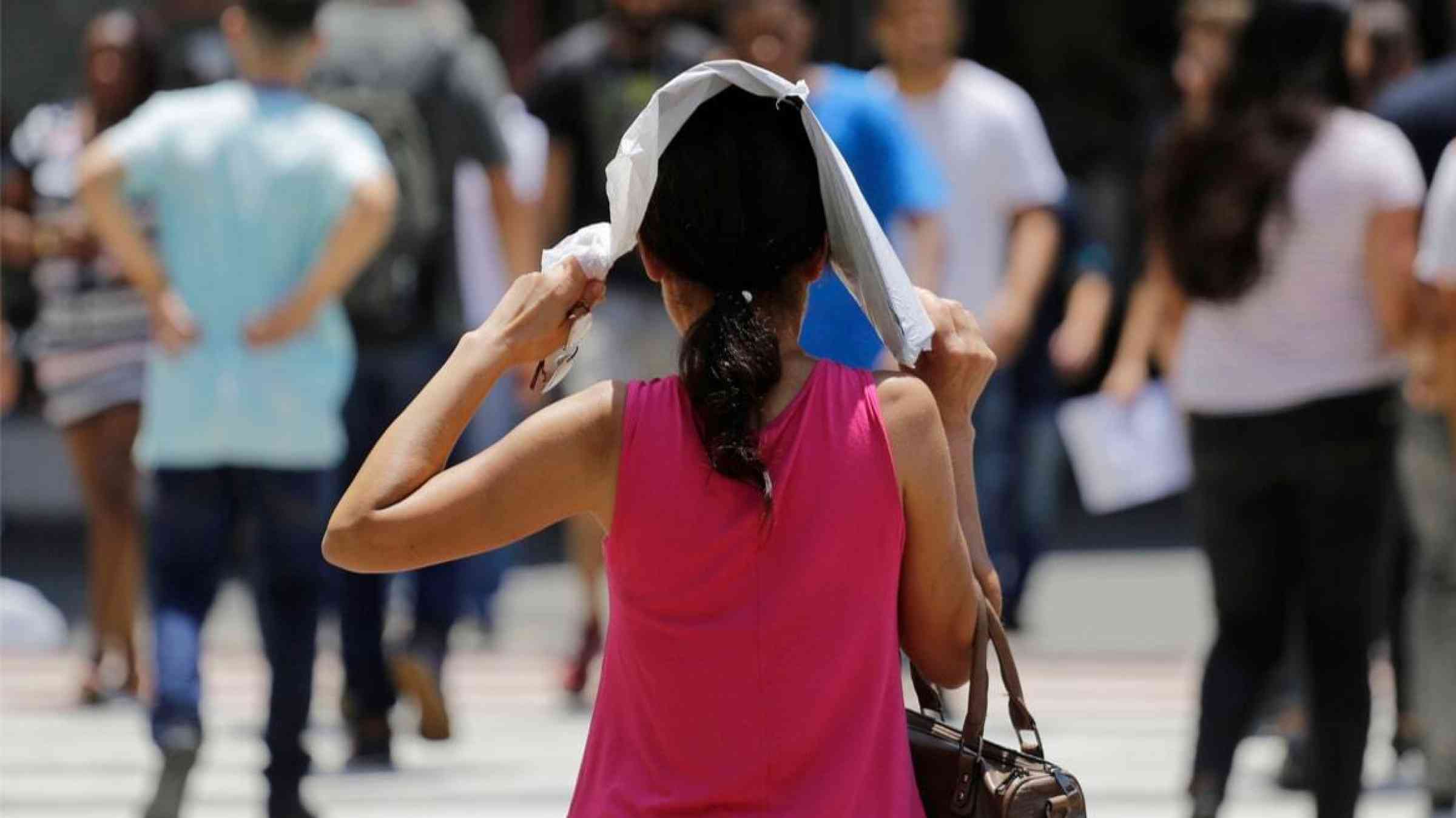 A woman protects herself from the hot sun in Sao Paulo, Brazil.