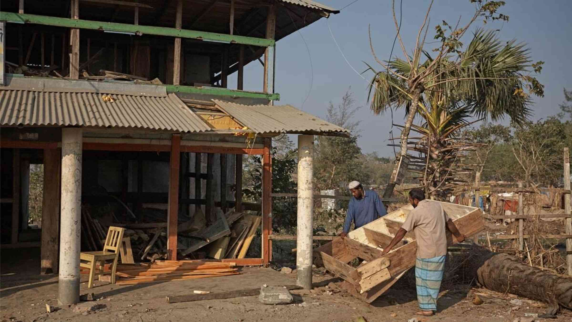 Men repairing their homes after Cyclone Sidr, Bangladesh