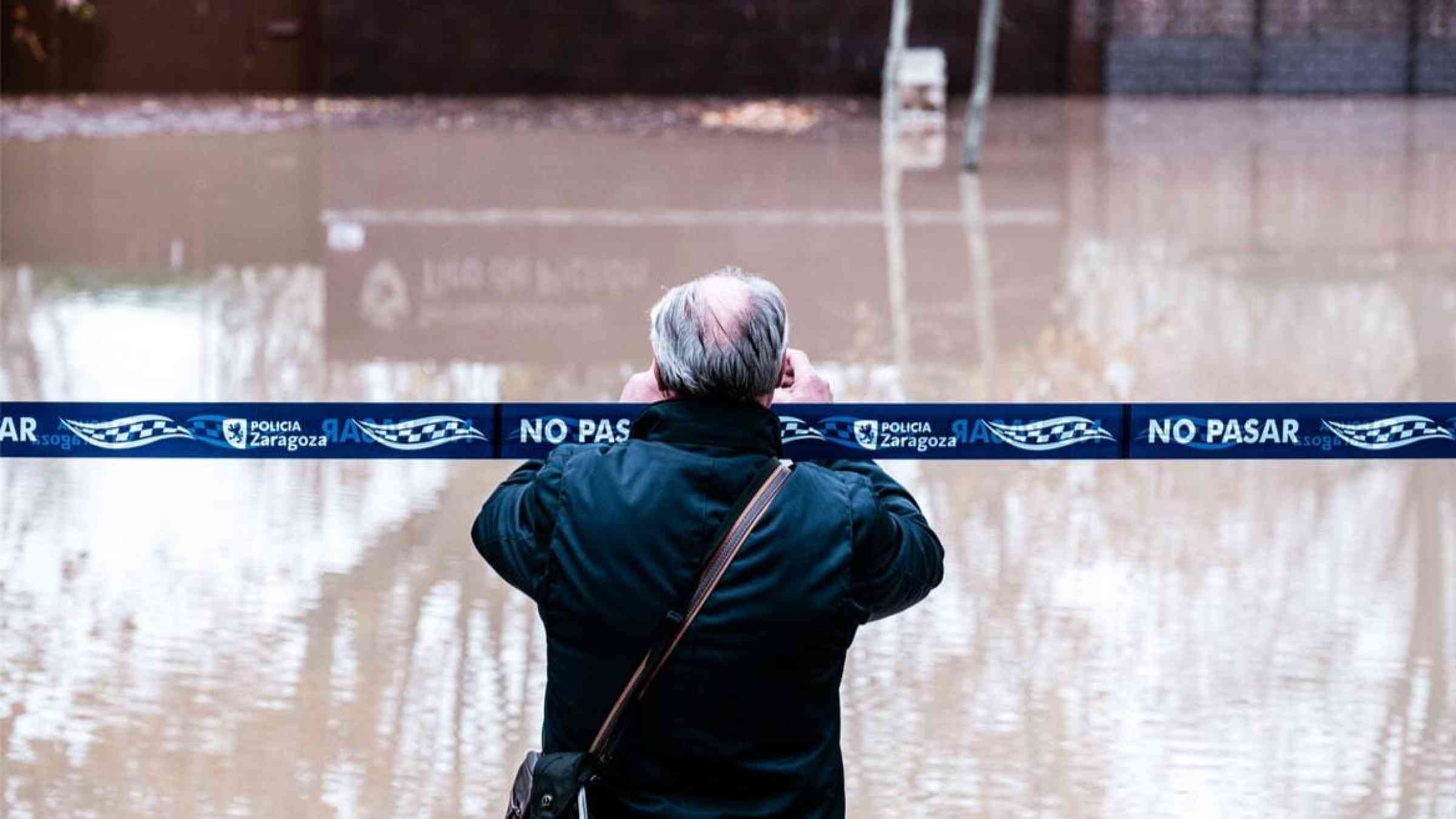 A bystander takes a photo of floods in Zaragoza, Spain