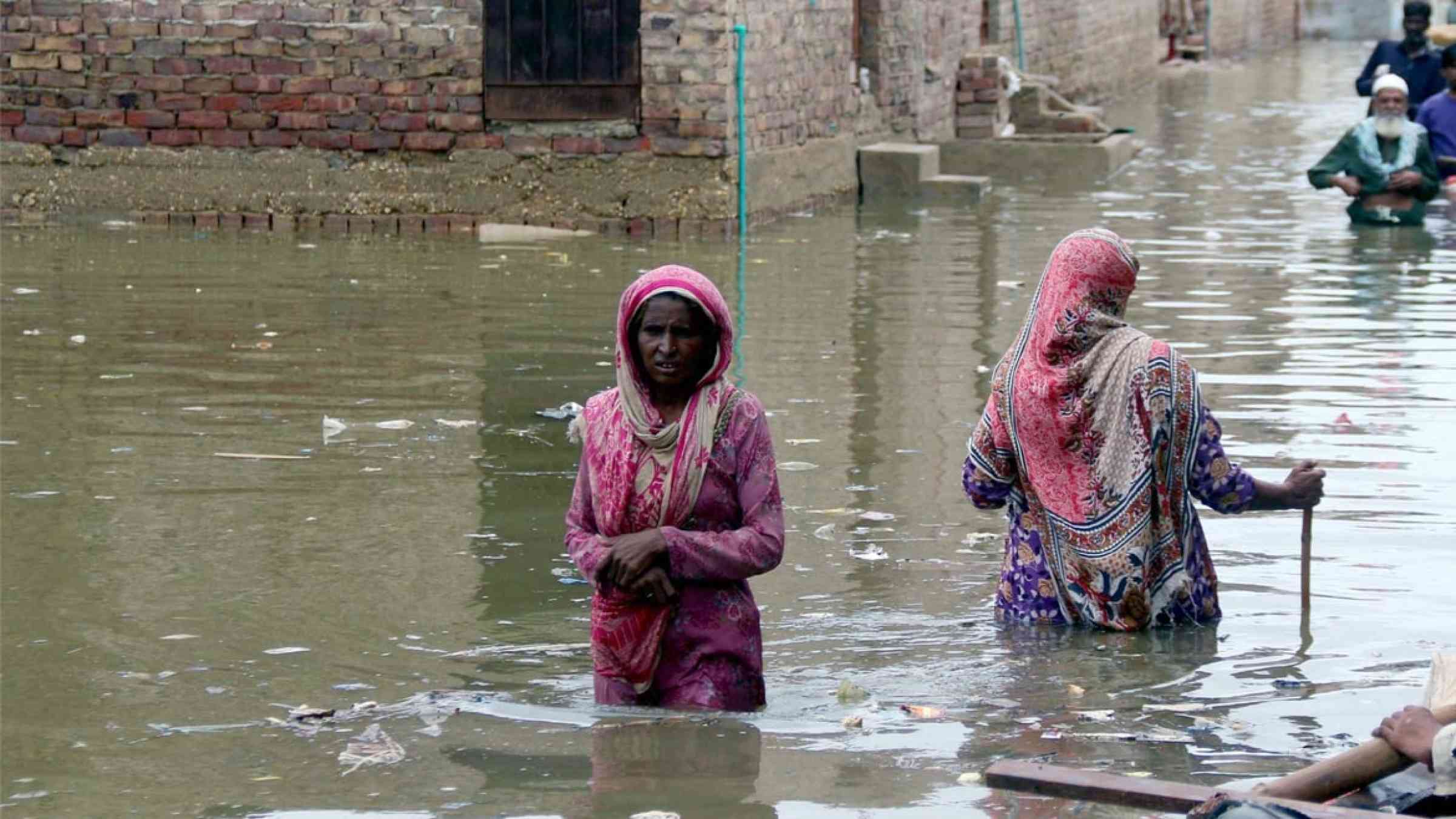 People walking in flooded water in Pakistan