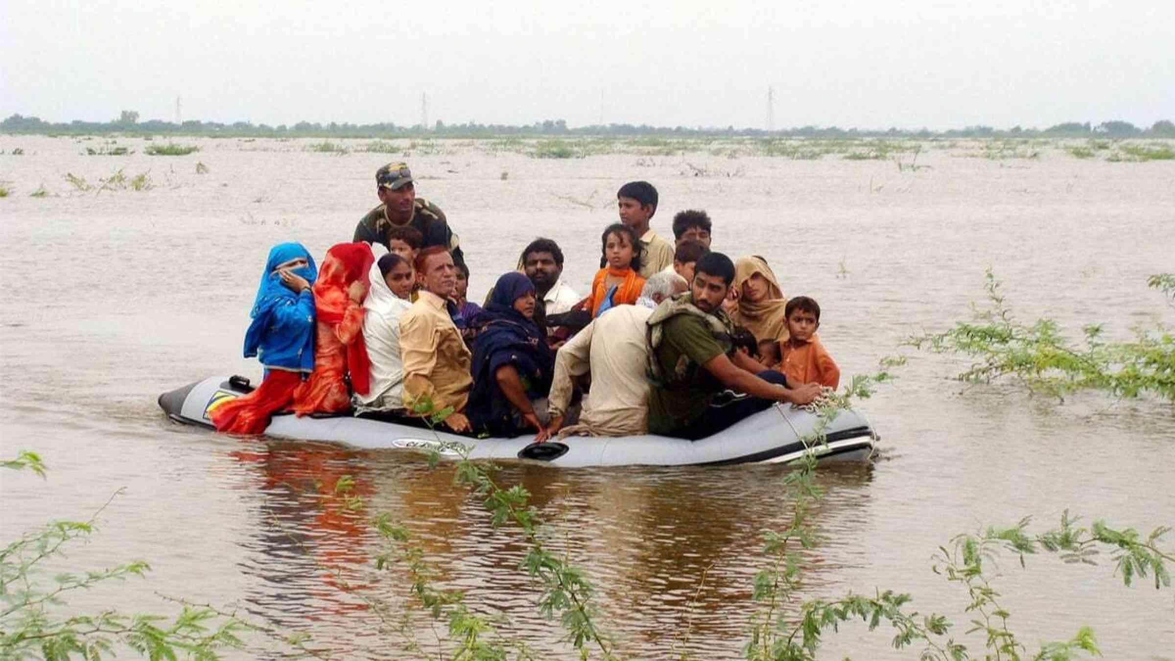A group of civilians are moved to safety by boat amid deep floods in Badin, Pakistan