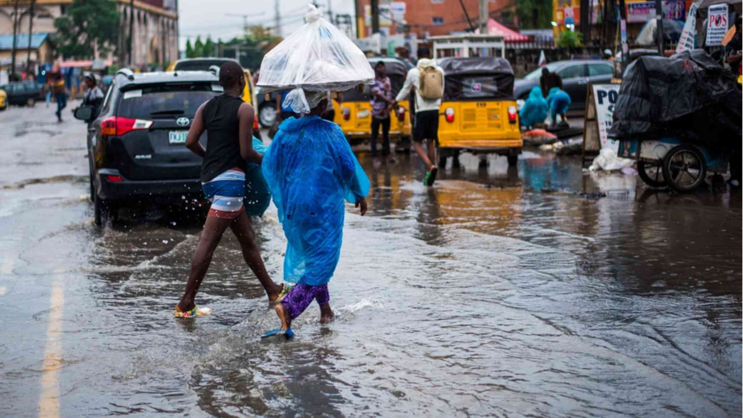Two women walking through the flooded streets of Lagos, Nigeria.