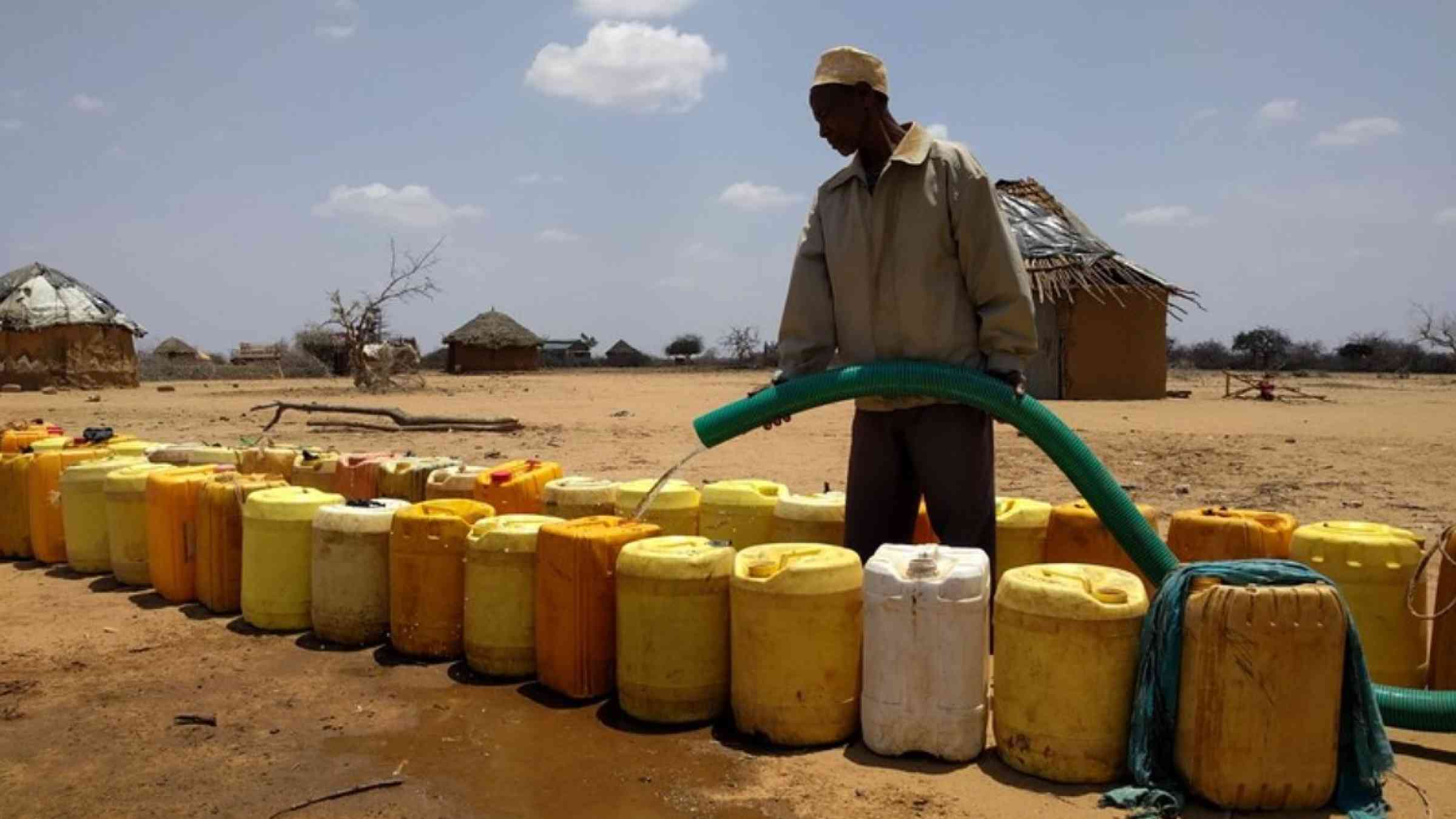 A villager distributes water to be used by households during a drought in northern Kenya