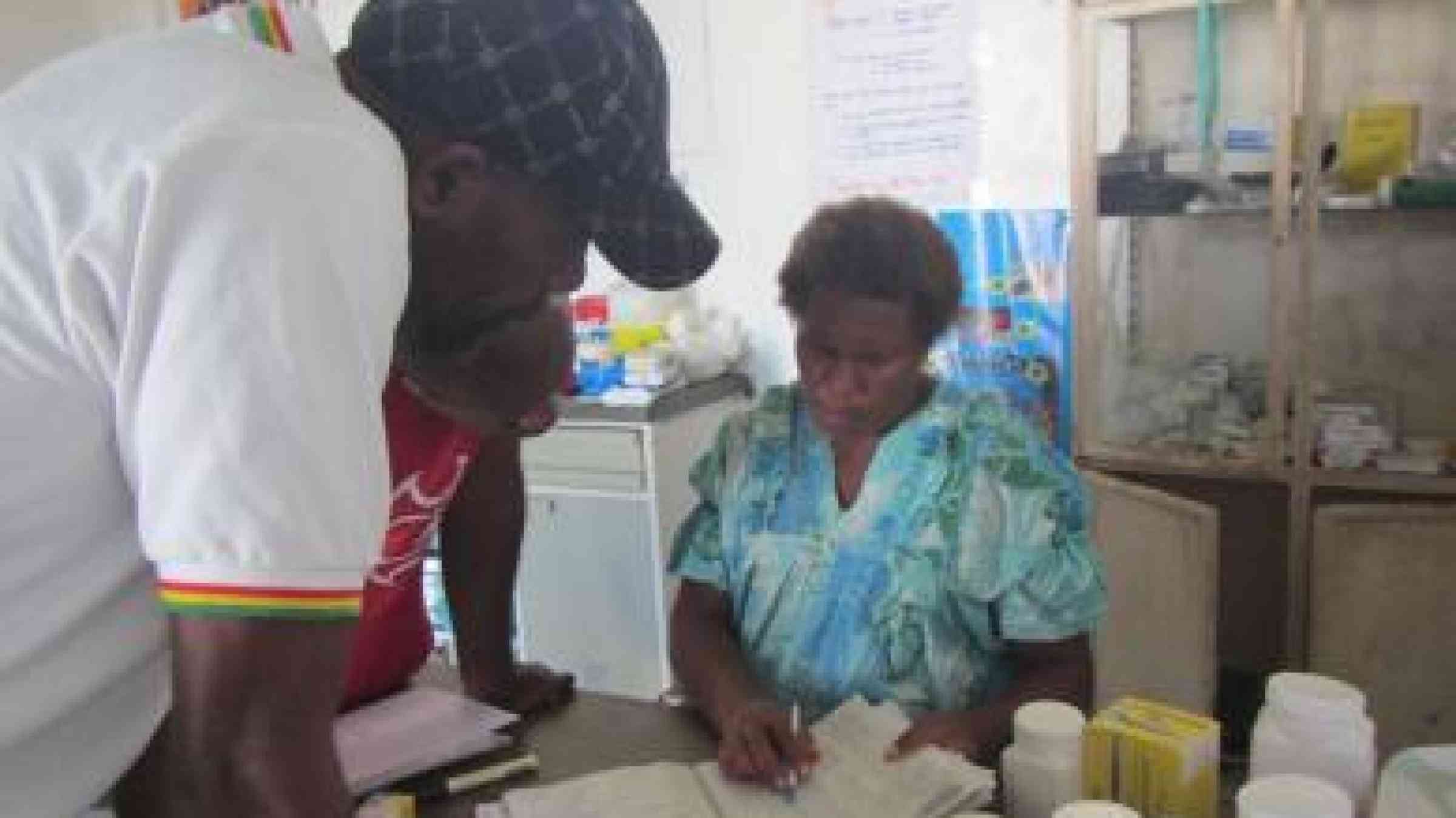 Health clinic staff in Tanna check health surveillance records, as Vanuatu rebuilds after tropical cyclone Pam. Photo by Paul White/Secretariat of the Pacific Community