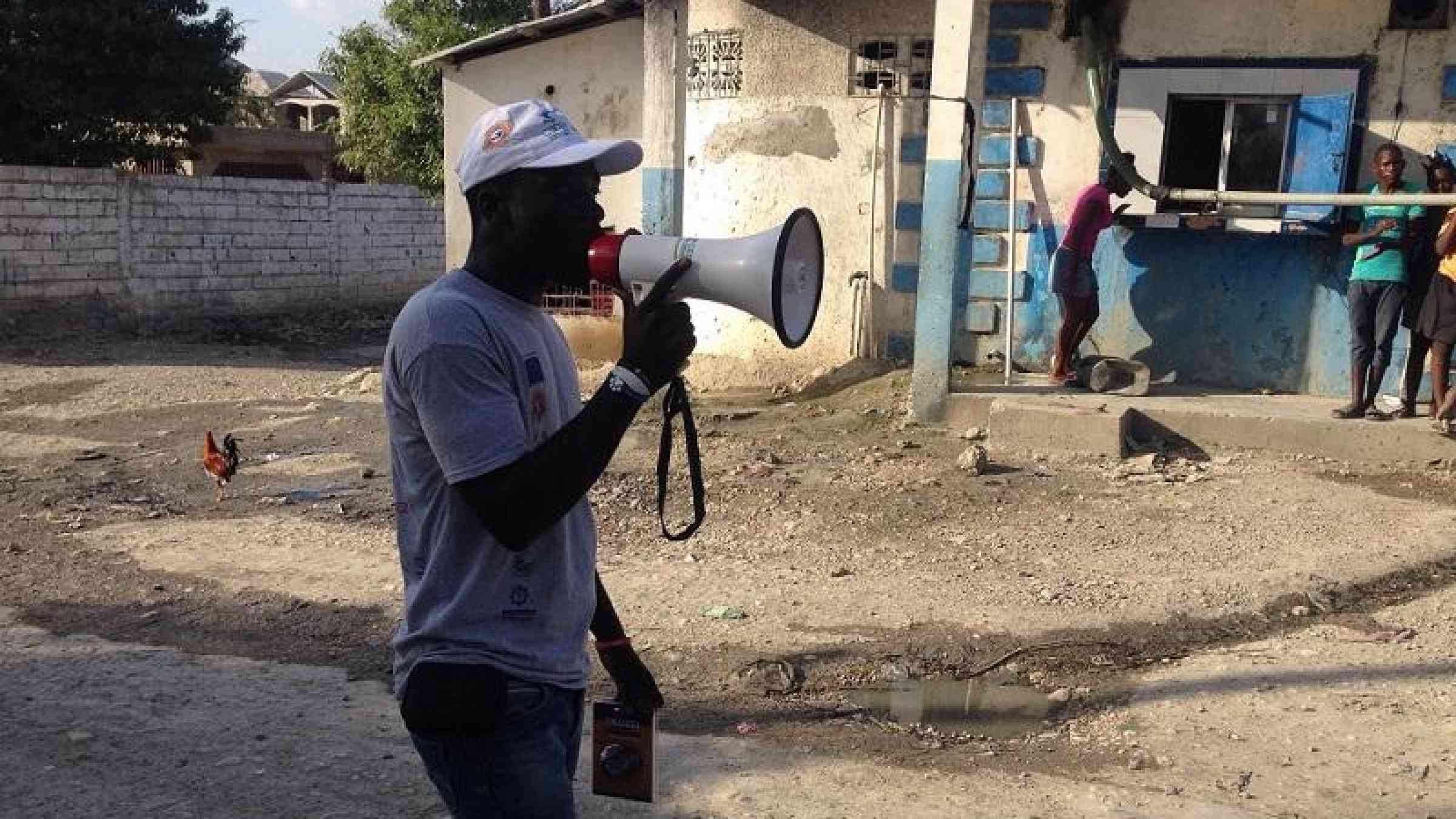 Man speaking in a megaphone. Photo: COOPI