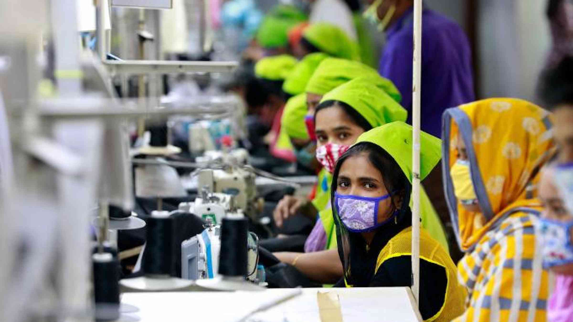 Dhaka, Bangladesh - March 31, 2020: Workers producing personal protective equipment (PPE) for health professionals at a garment factory of Urmi Group. Sk Hasan Ali / Shutterstock.com