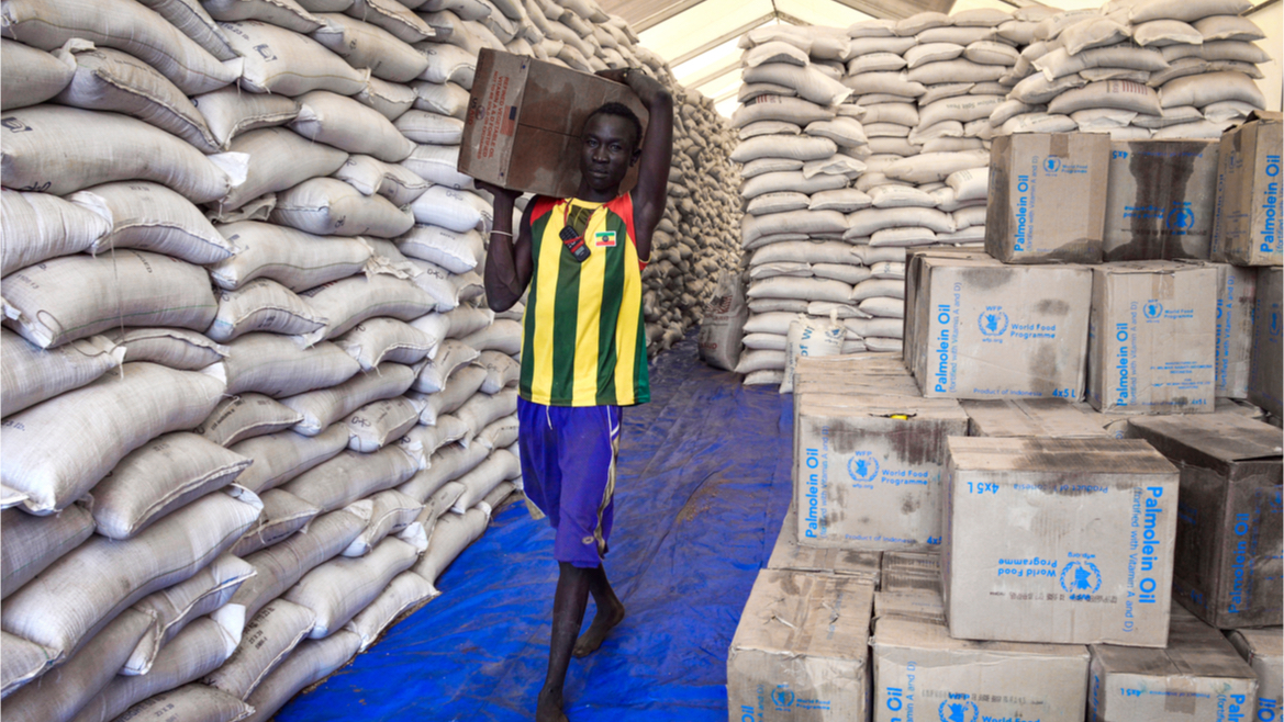 A man brings food aid packs out of a warehouse in Gambela, Ethiopia