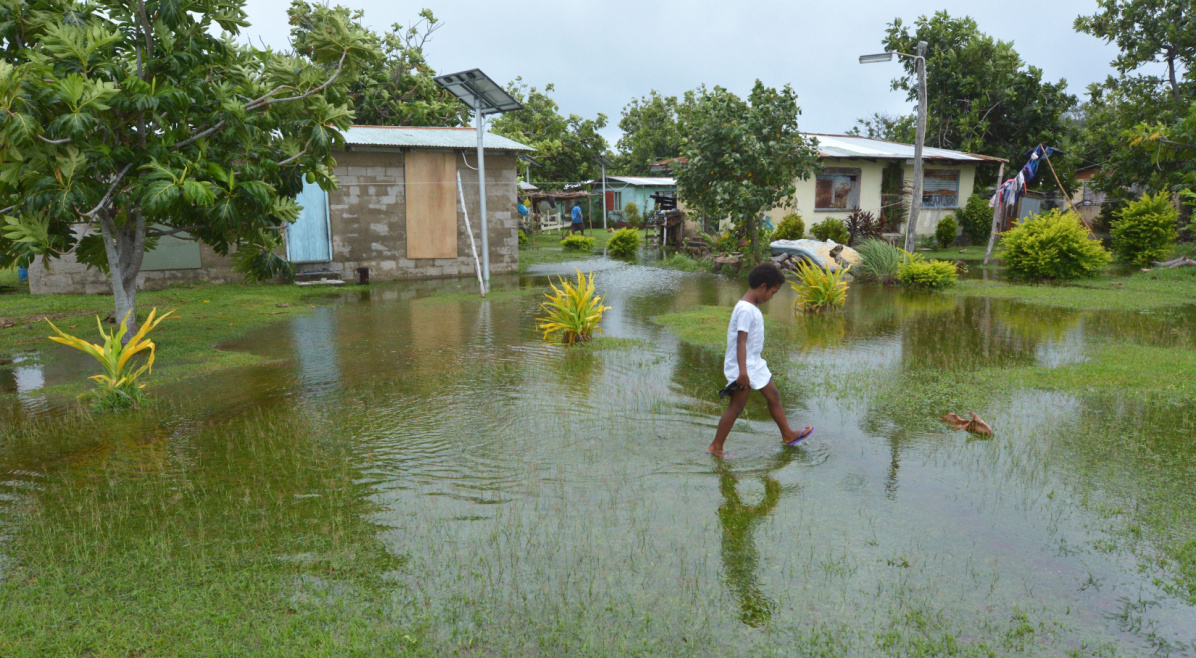 Niña indígena de Fiyi caminando sobre terreno inundado en Fiyi