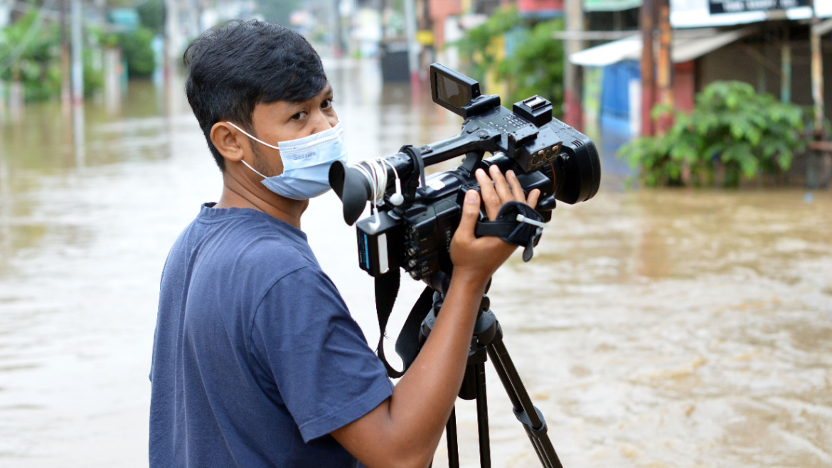 Television journalists covering the Bekasi flood, Indonesia in 2021