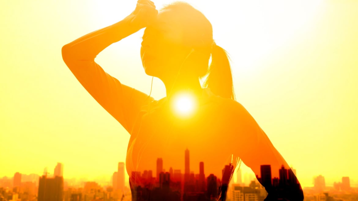 Double exposure portrait of young woman hand wiping sweat with summer heat wave background