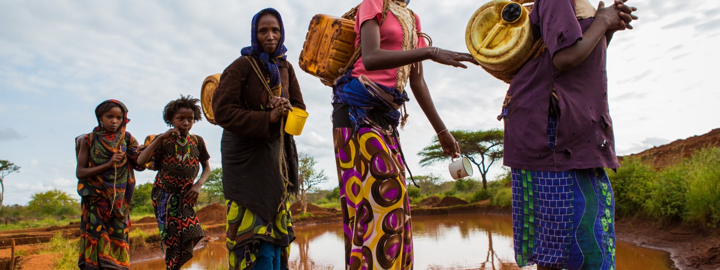 Women from the African region walking in line to collect water