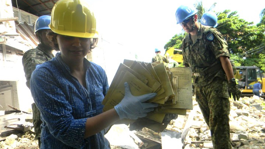 Photo: Aparna retrieving documents from debris in the Philippines. 