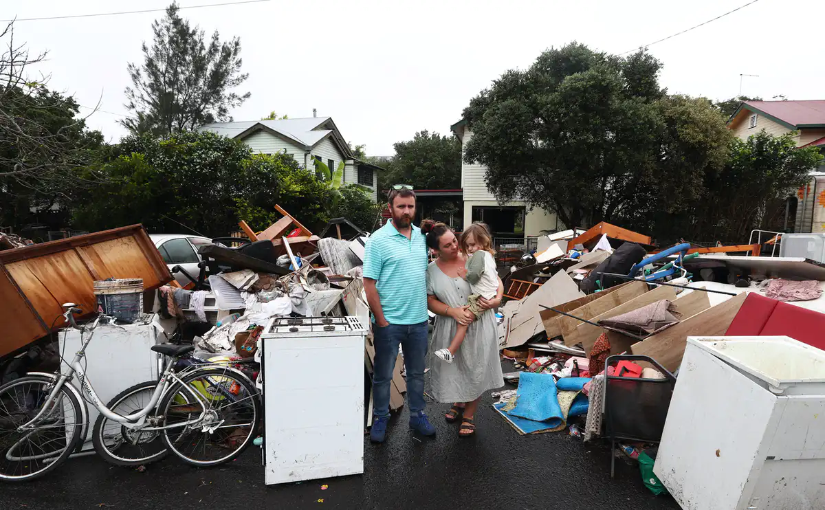 Lismore residents Tim Fry and Zara Coronakes and son Ezekiel outside their home on March 11 2022.&nbsp;Jason O'Brien/AAP,&nbsp;CC BY