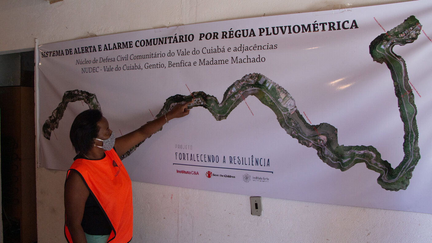 Christina Rosario de Oliveira explaining flood monitoring using a river map