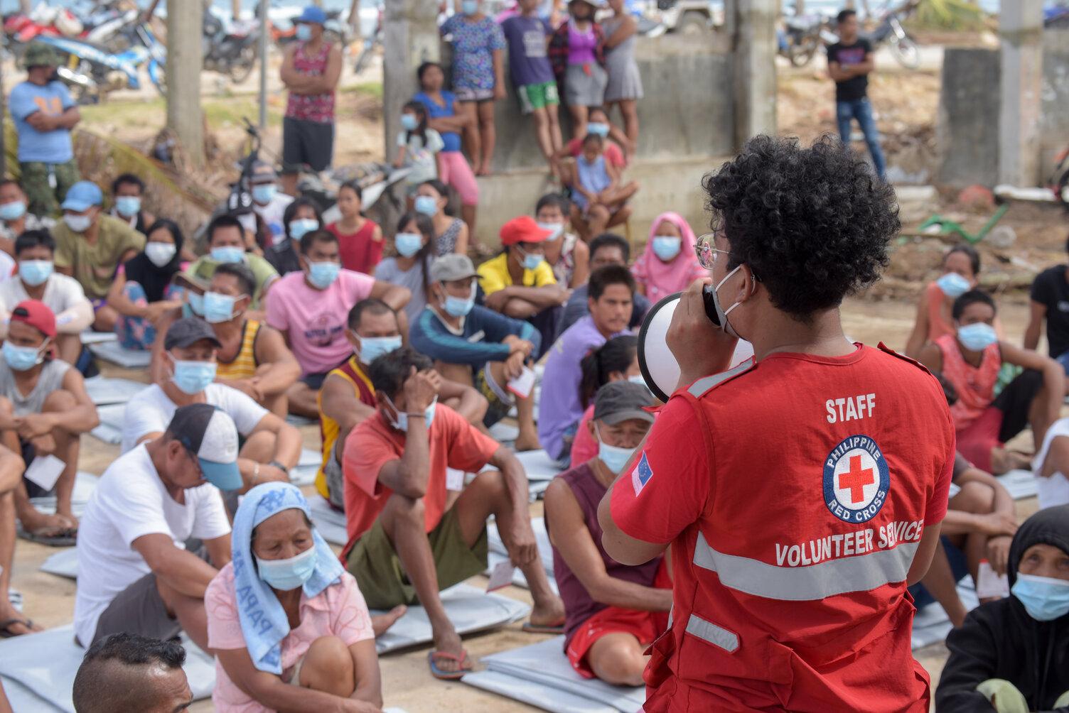 A Philippine Red Cross volunteer organizing relief distribution on Christmas Day, December 25, 2021, in Siargao , few days after Typhoon Rai hit the island. Anticipatory Action mechanisms were not triggered. Since then, lessons learnt from the typhoon have helped improve early action frameworks.
