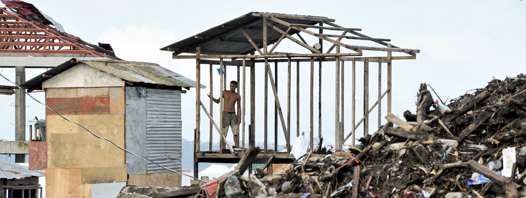 Man overviewing disaster scene after Typhoon Haiyan in the Philippines, 2013
