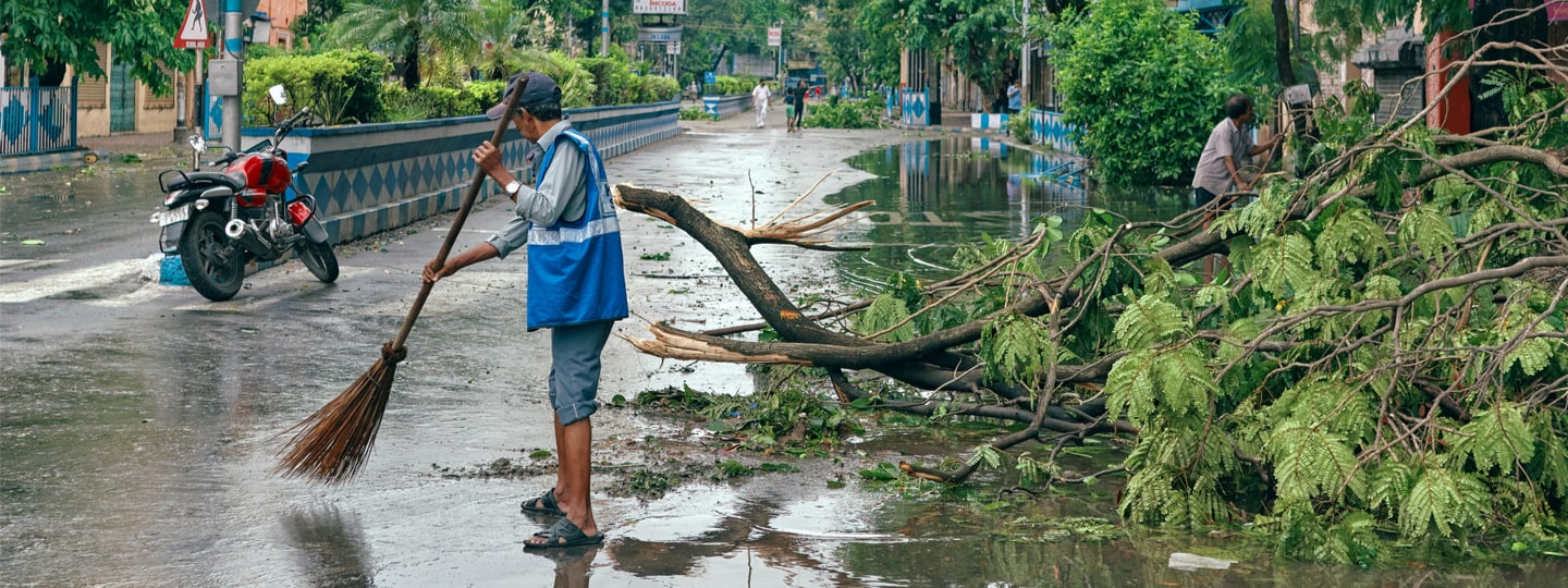 A municipal worker cleaning the street in the city of Kolkata following the passage of Cyclone Amphan in India (2020) 