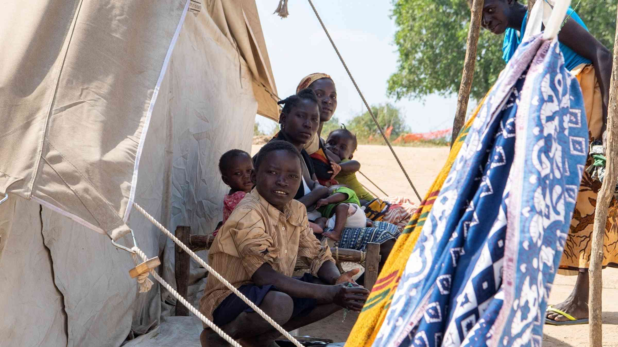 A family outside of their tent in the Taratara Camp, in Cabo Delgado province