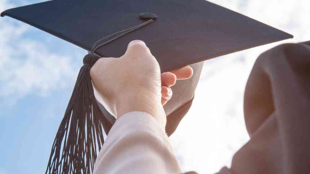 Graduates of the university, by graduates, passing hats to the sky.