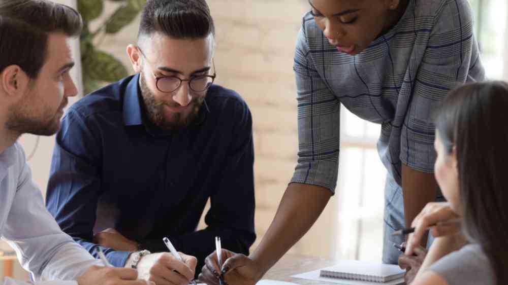 Serious African female boss of bosses of bosses teach various board staff, explain project plan documents at group meetings, focused black female mentor training teams at company meetings