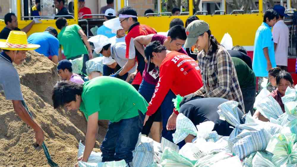 Thai people making sandbags to prevent flooding during the monsoon season in Bangkok, Thailand 