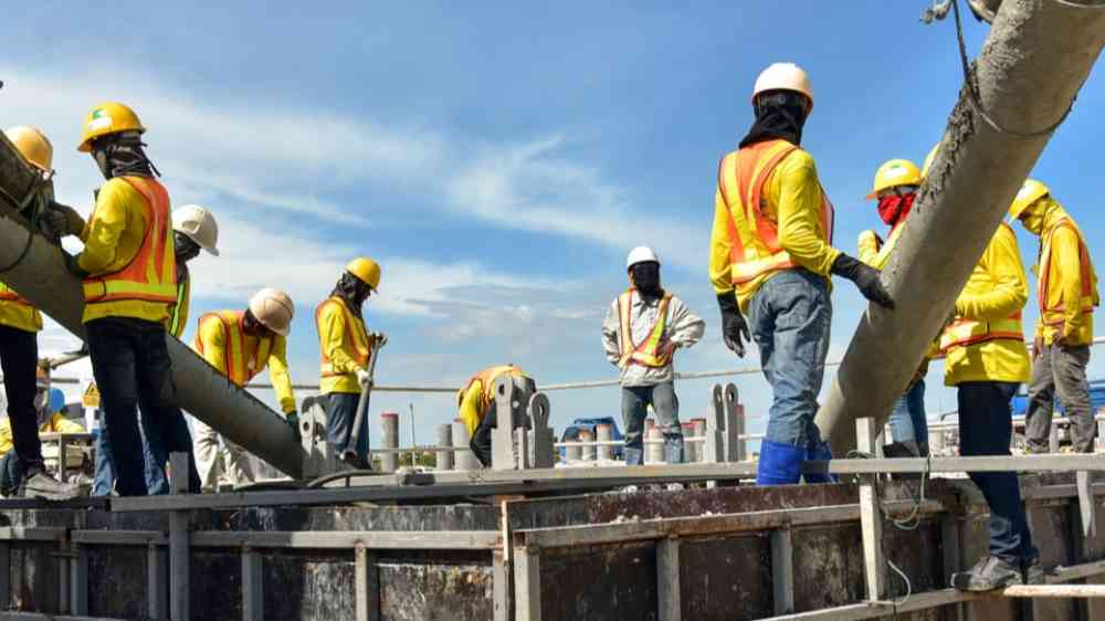 Construction workers pouring concrete in a construction site