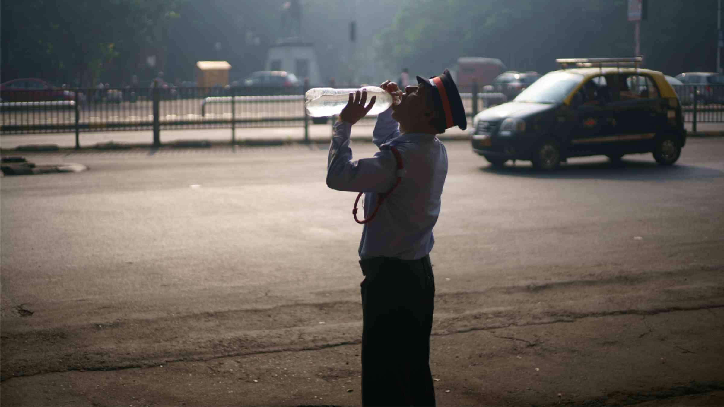 A security guard of a local residential building is drinking water to beat the heat in Mumbai, India (2017)