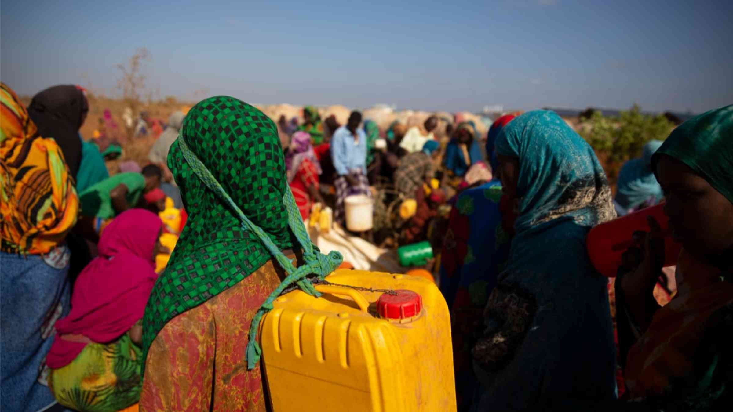 Women living in refugee camps due to drought in Somalia are waiting for water distribution 