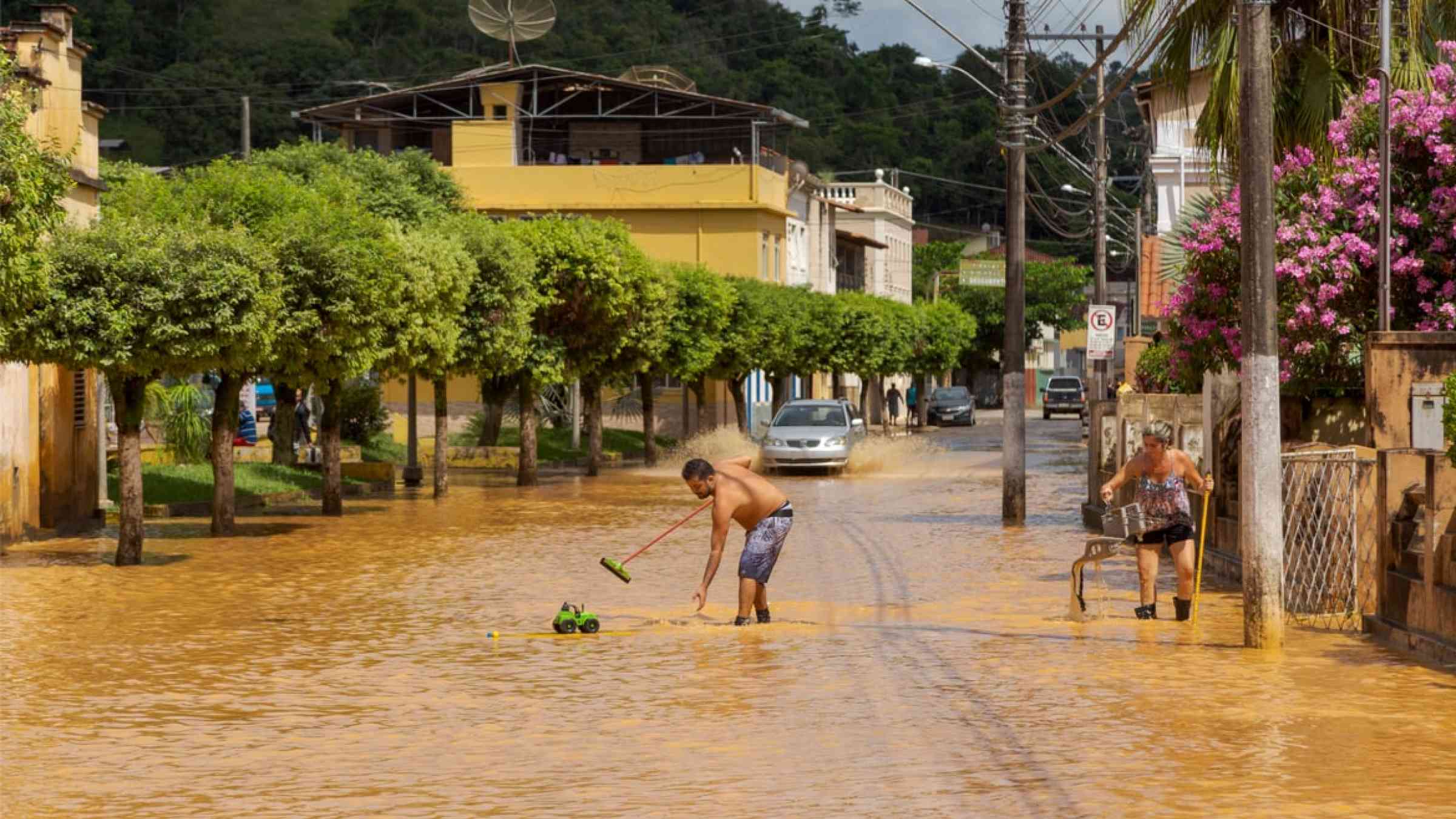 Man removes a toy in the flood water of the Pomba River, in a flooded street in the center of the city of Guarani, state of Minas Gerais, Brazil (2020)