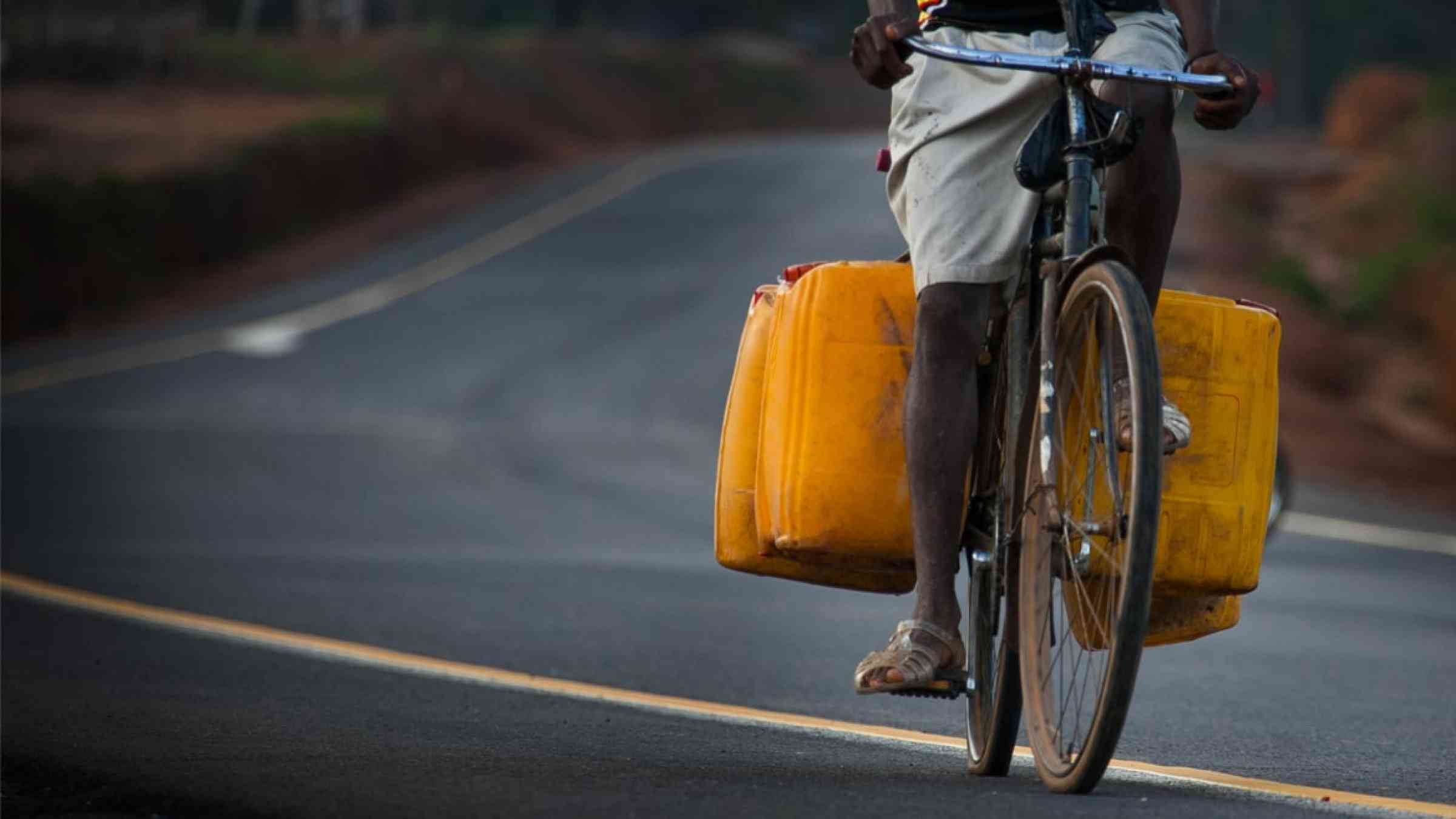 Person transporting water on their bicycle