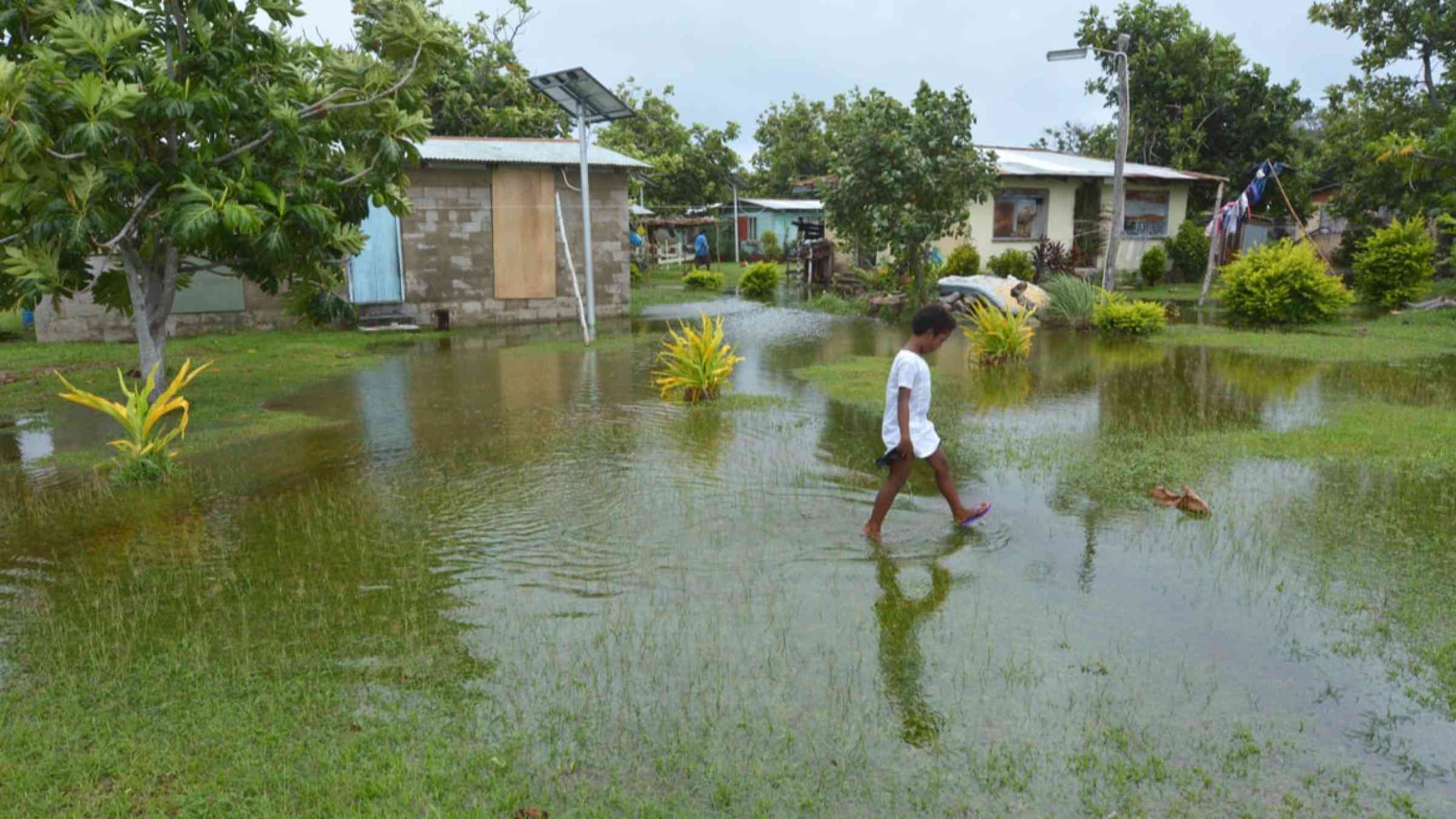 Child walking in an inundated area in Fiji following Cyclone Winston in 2016