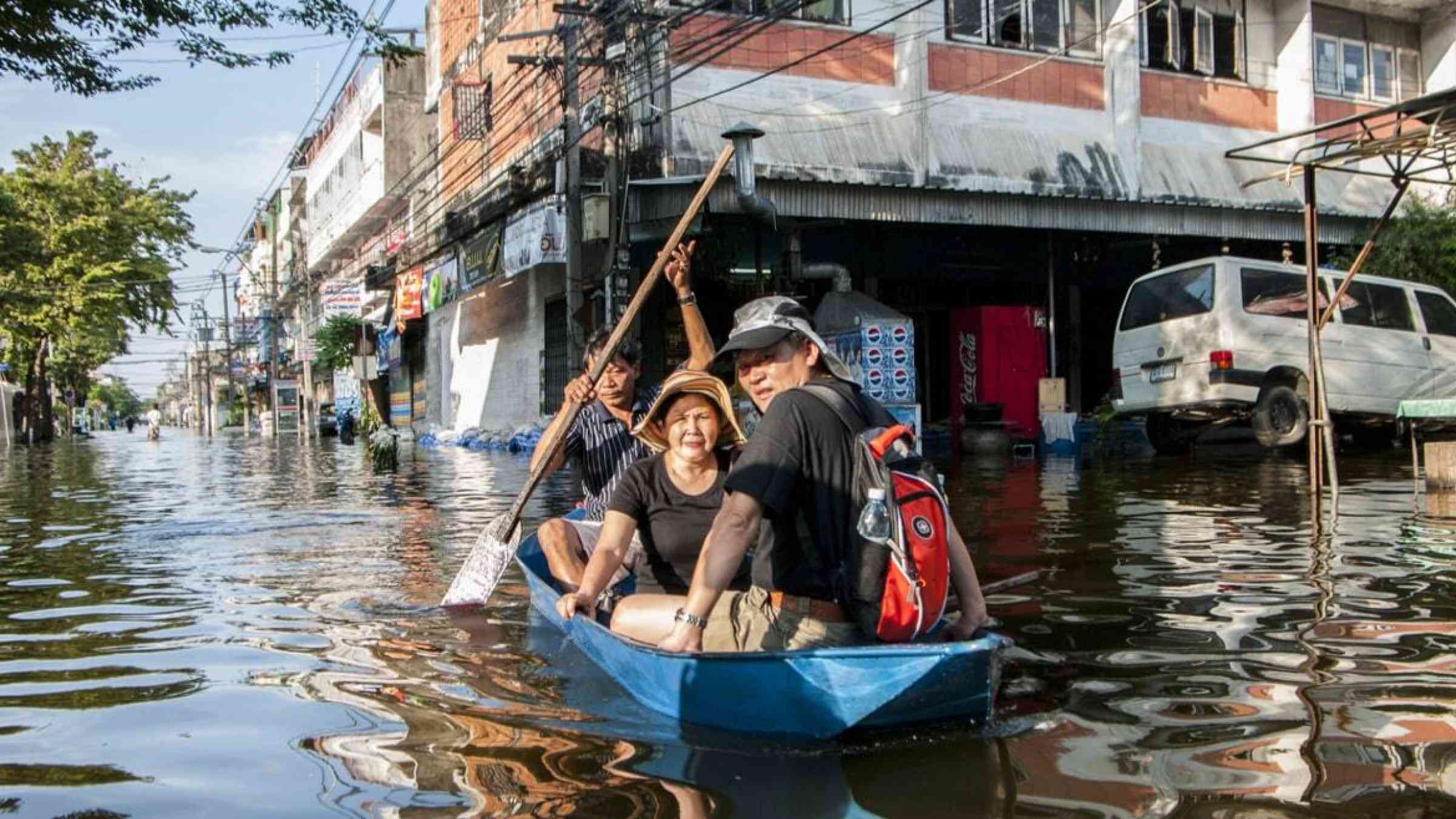 Bangkok residents navigate heavy floods by boat