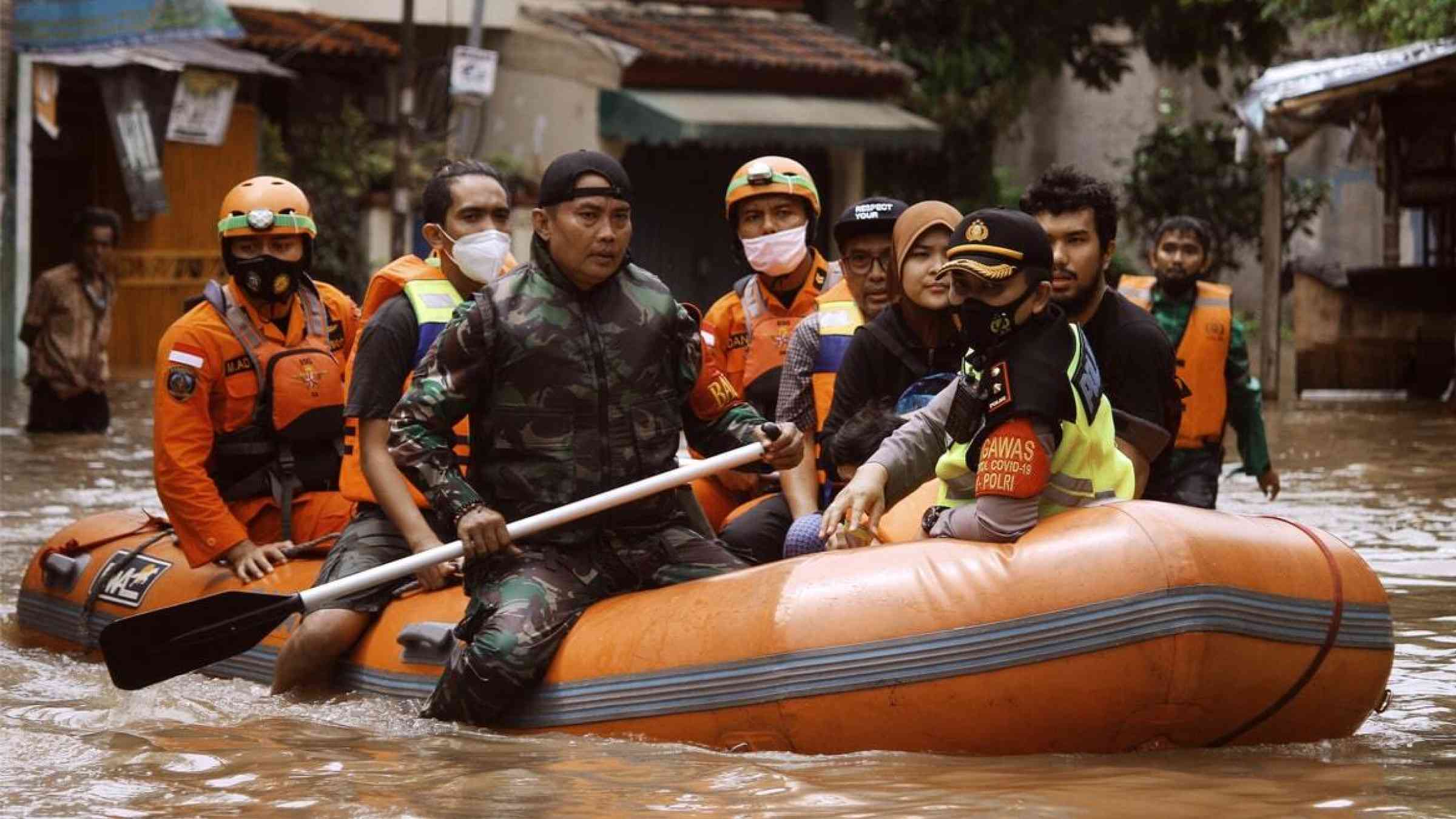 An Indonesian rescue team carries survivors to safety