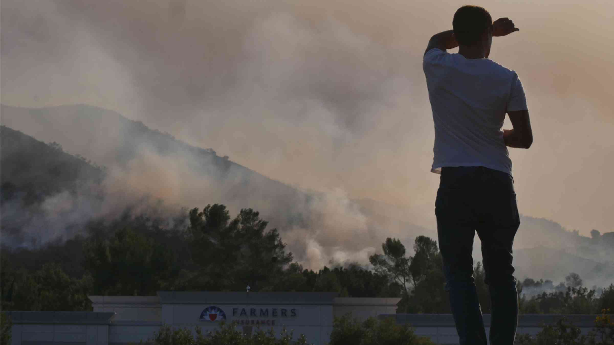A Los Angeles resident observes the approaching wildfire