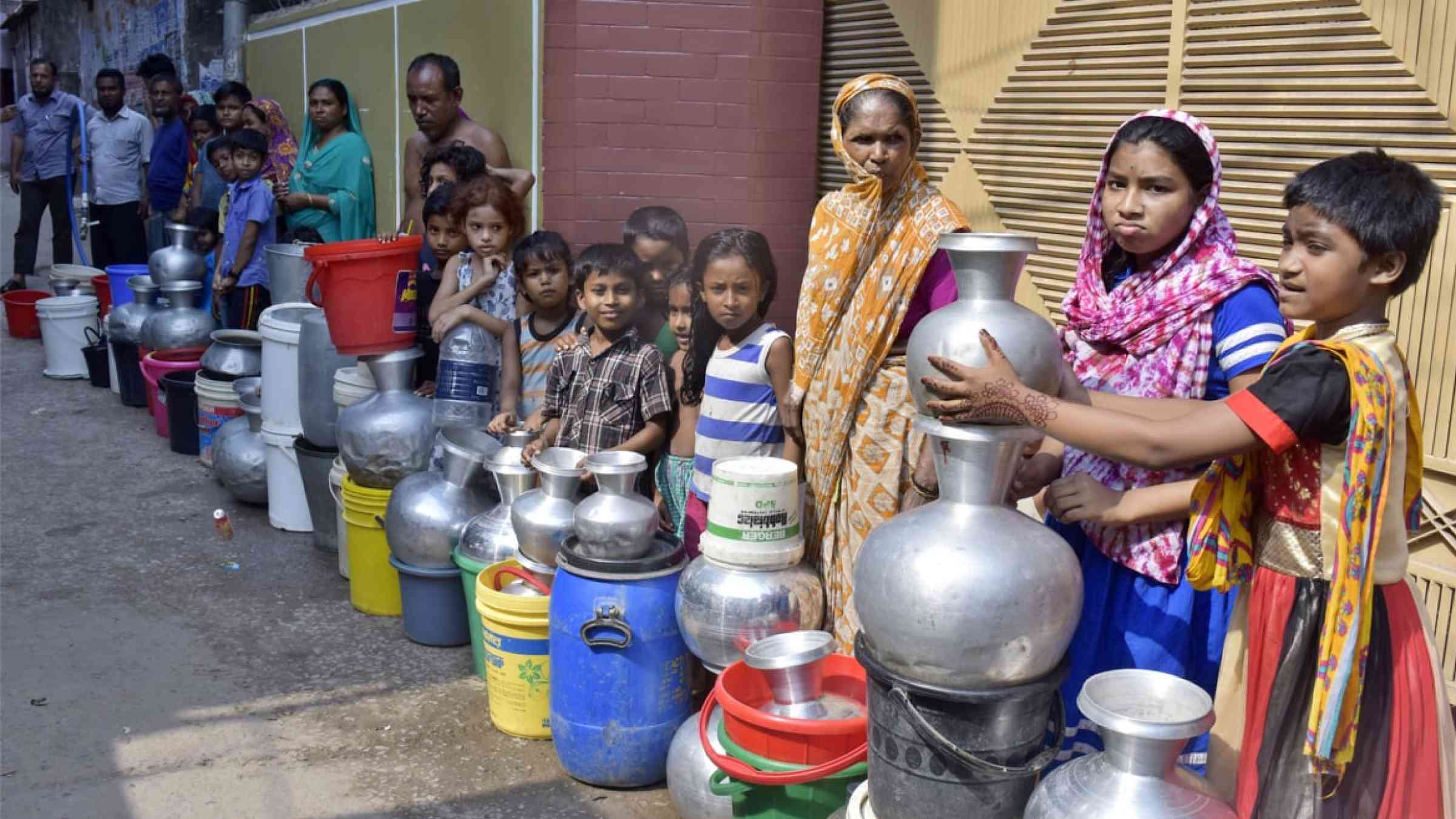 Residents of Dhaka, Bangladesh, wait to collect water from a water supply (2017)