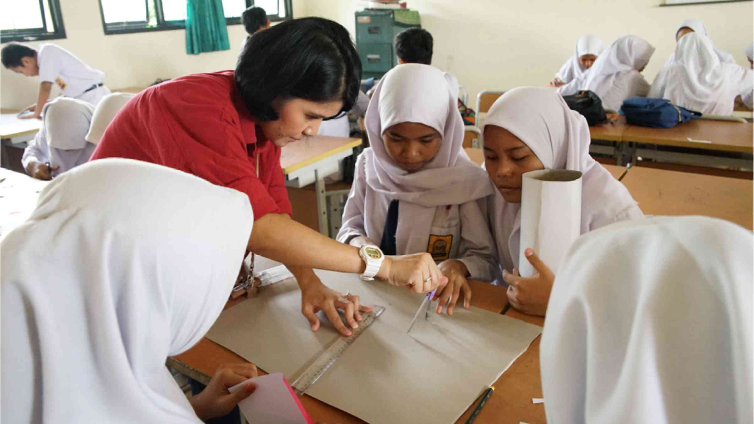 A teacher guides students in a class project