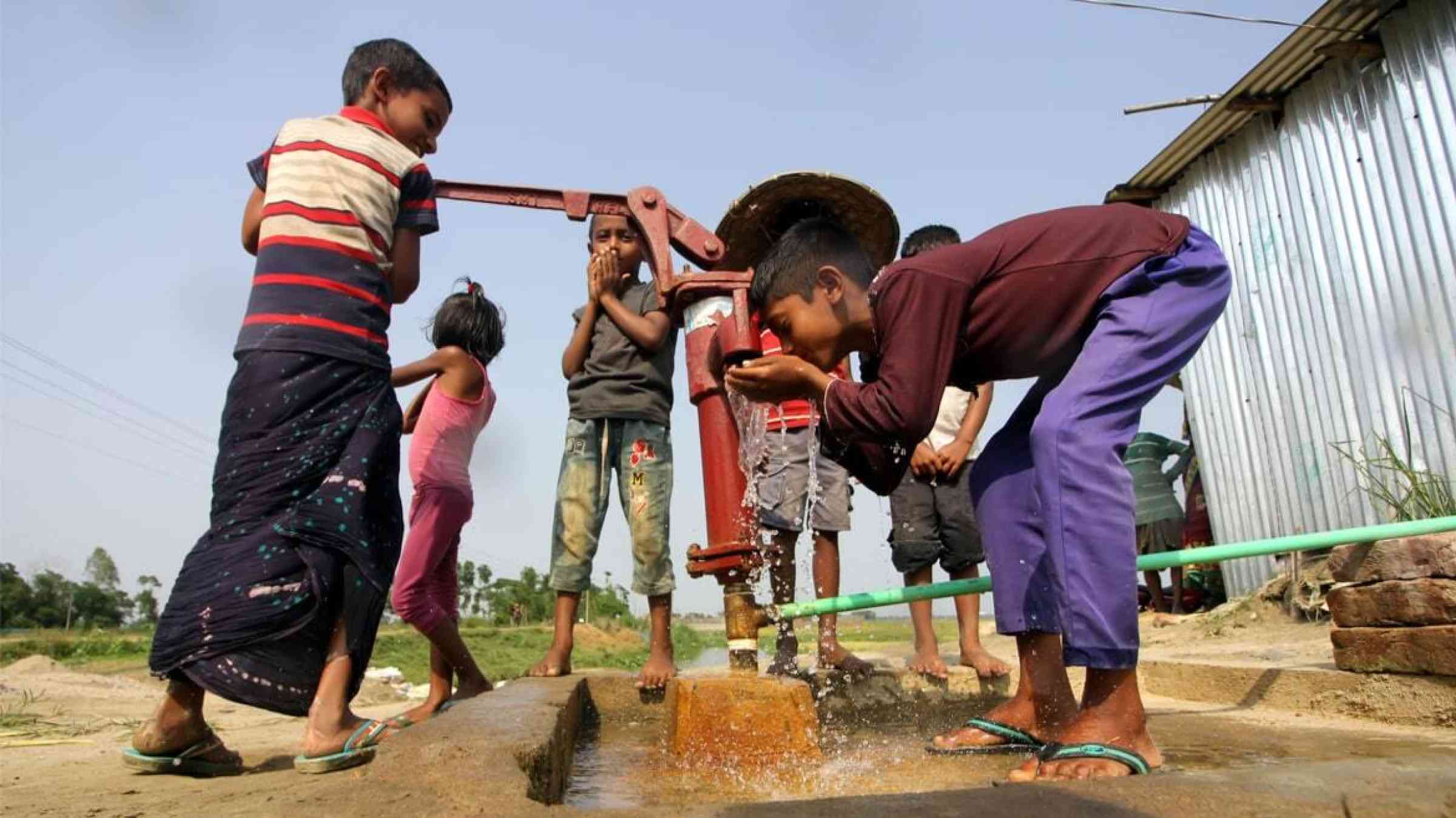 Children drink from a well in Bangladesh