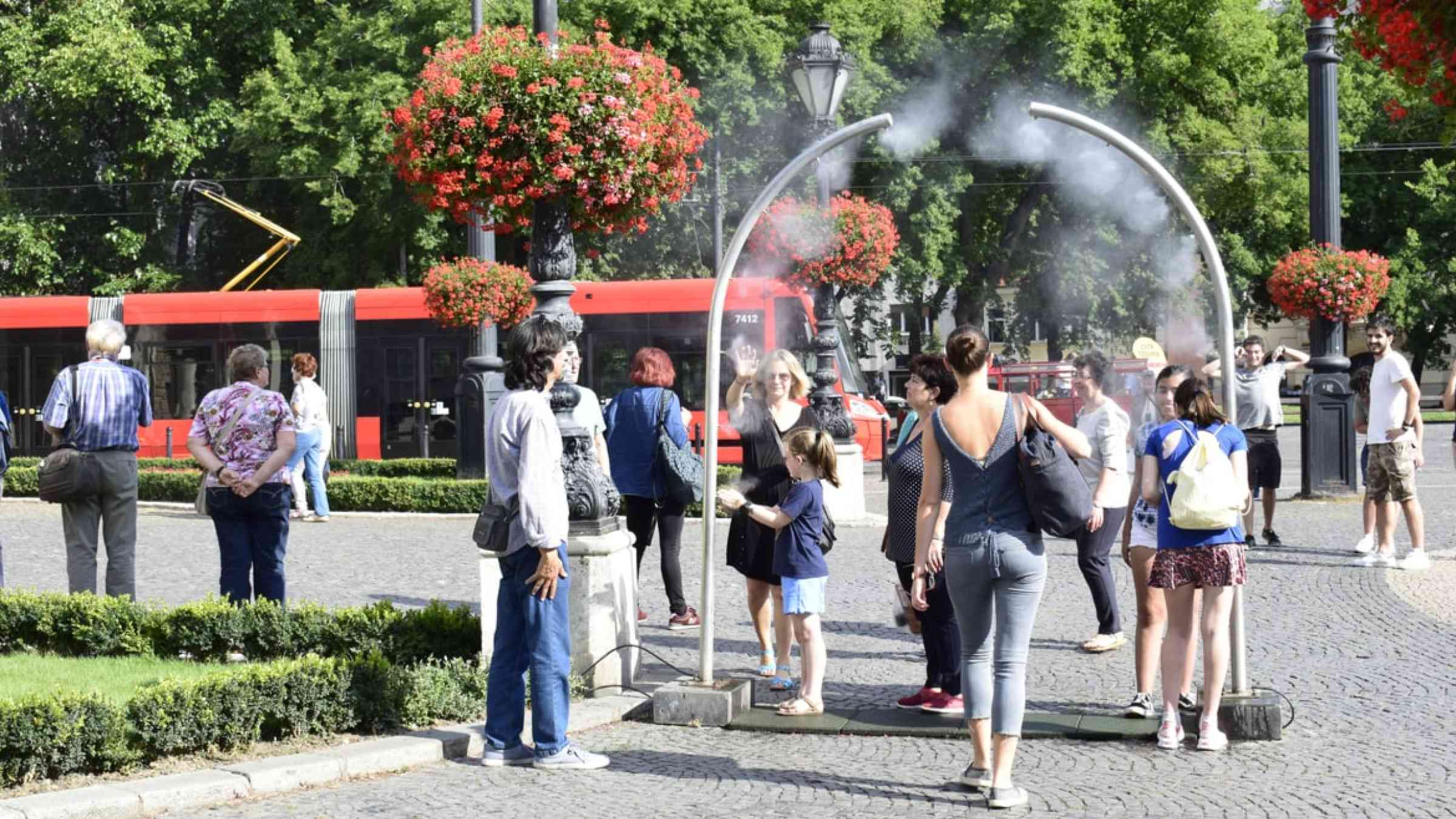 People enjoy a water spray in Bratislava, Slovakia on a summer day (2018)