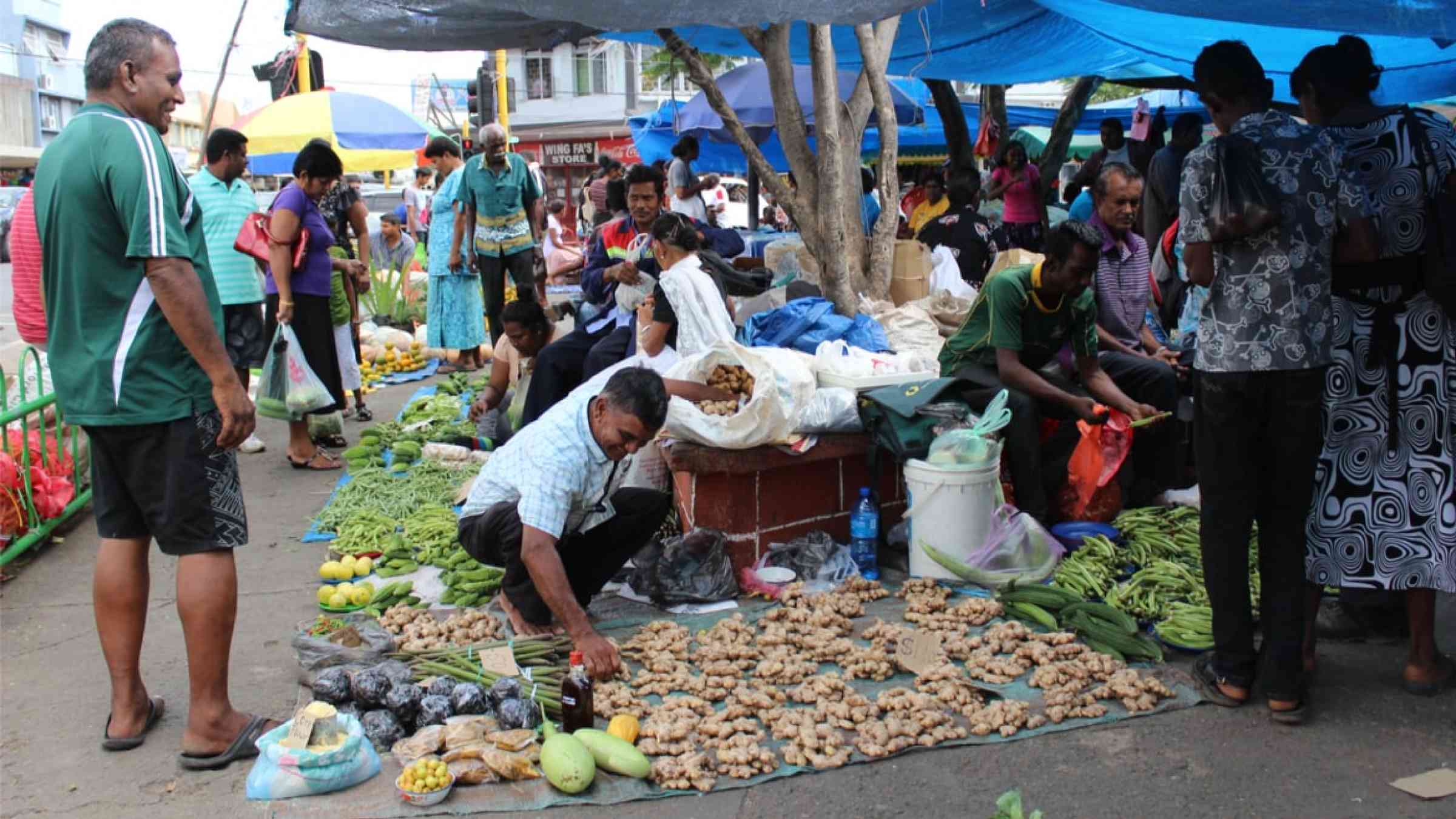 People buying and selling vegetables during the weekend market in Suva, Fiji (2015)