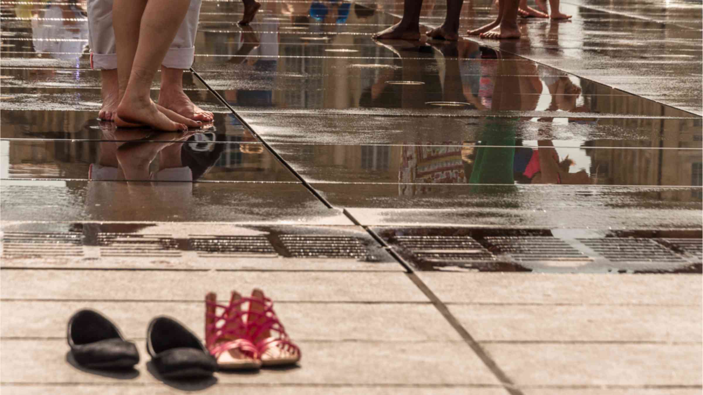 People cooling their feet in water in the city.