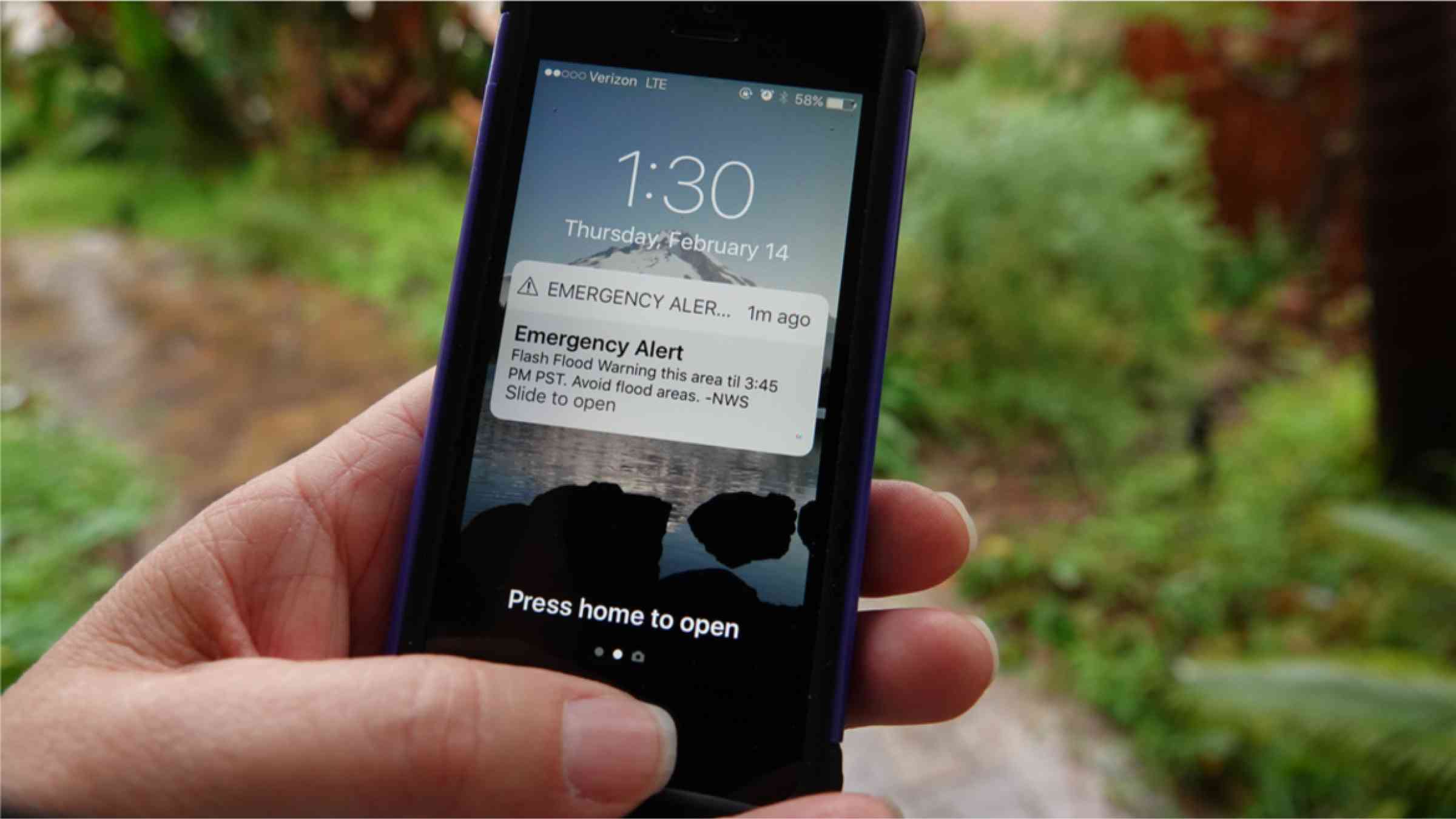 Emergency flash flood alert after heavy downpour displayed on smartphone.
