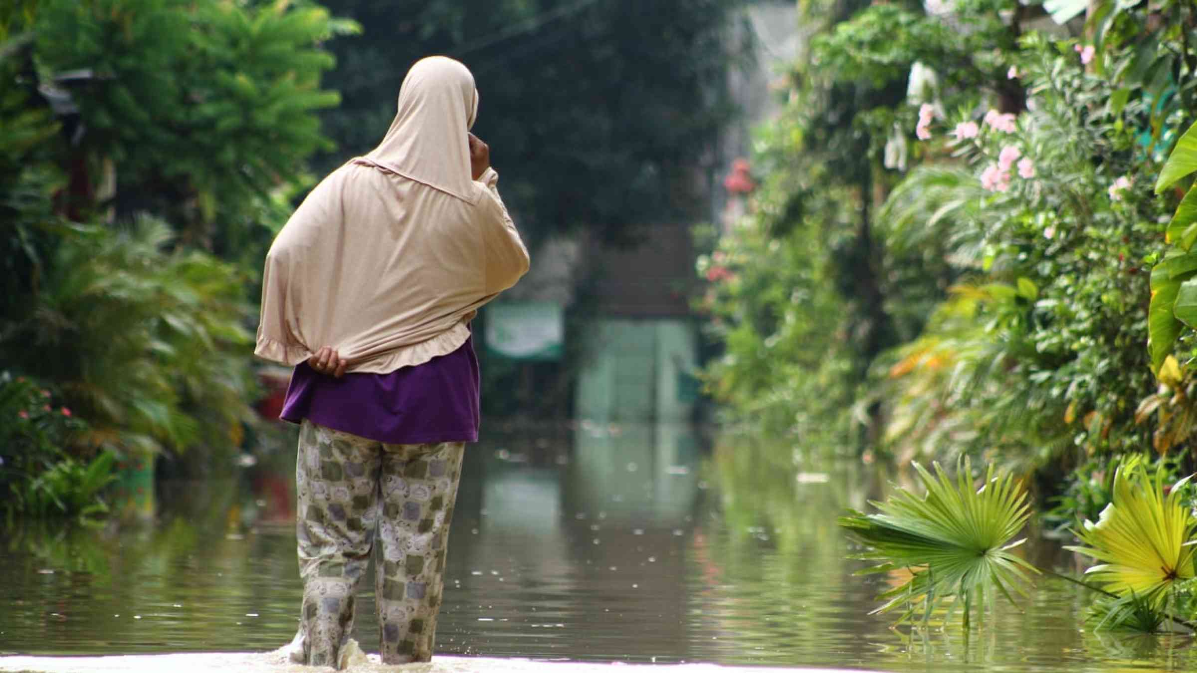 Woman walking in a flooded street in Bekasi, Indonesia
