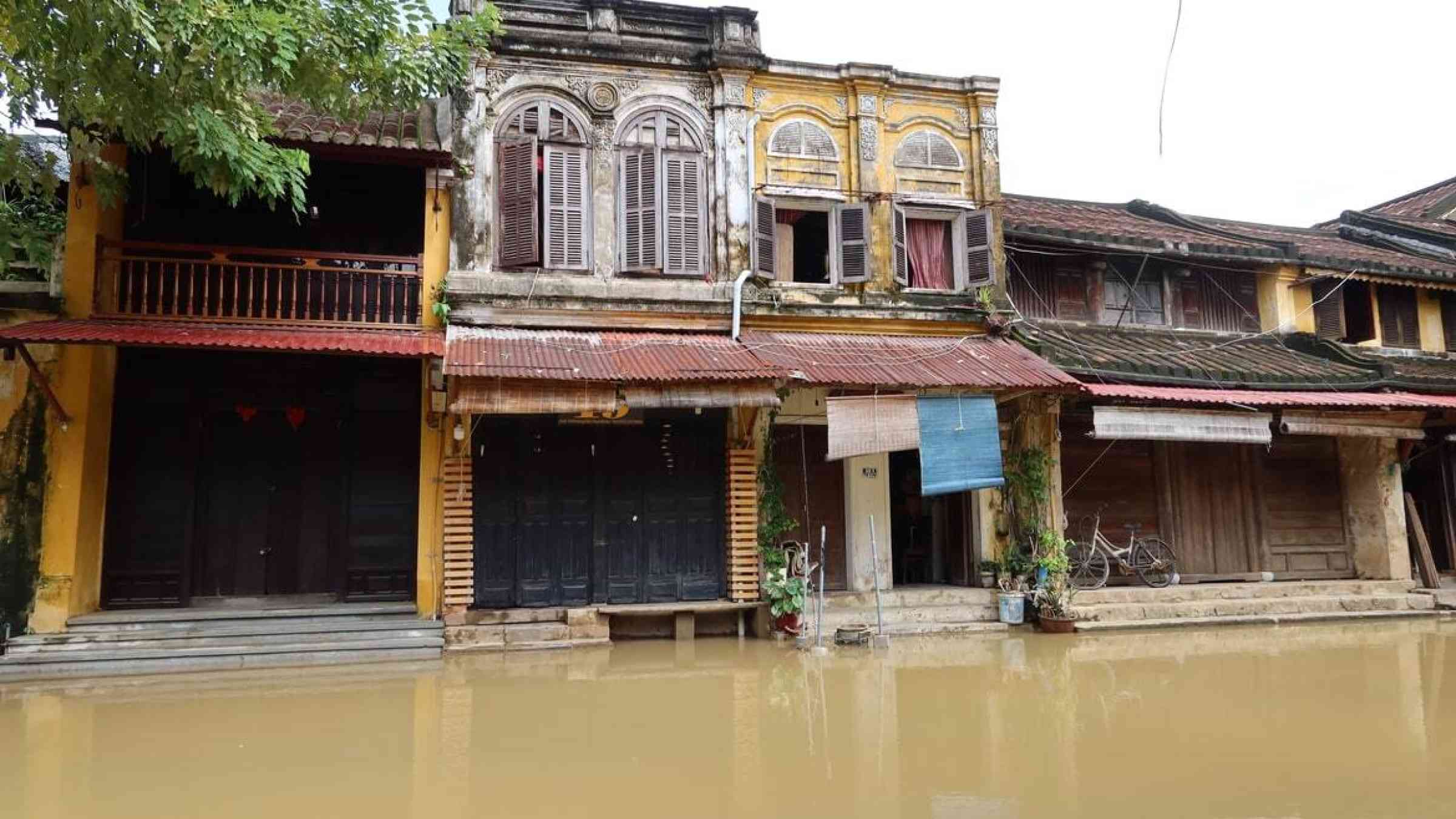 Old colonial buildings on a street in downtown Hoi An, Vietnam along the Thu Bon River flooded during the 2021 rainy season