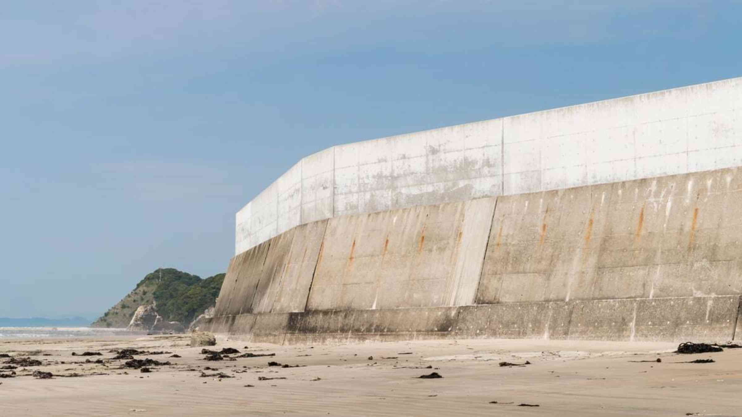 Concrete tsunami protection sea wall on a beach