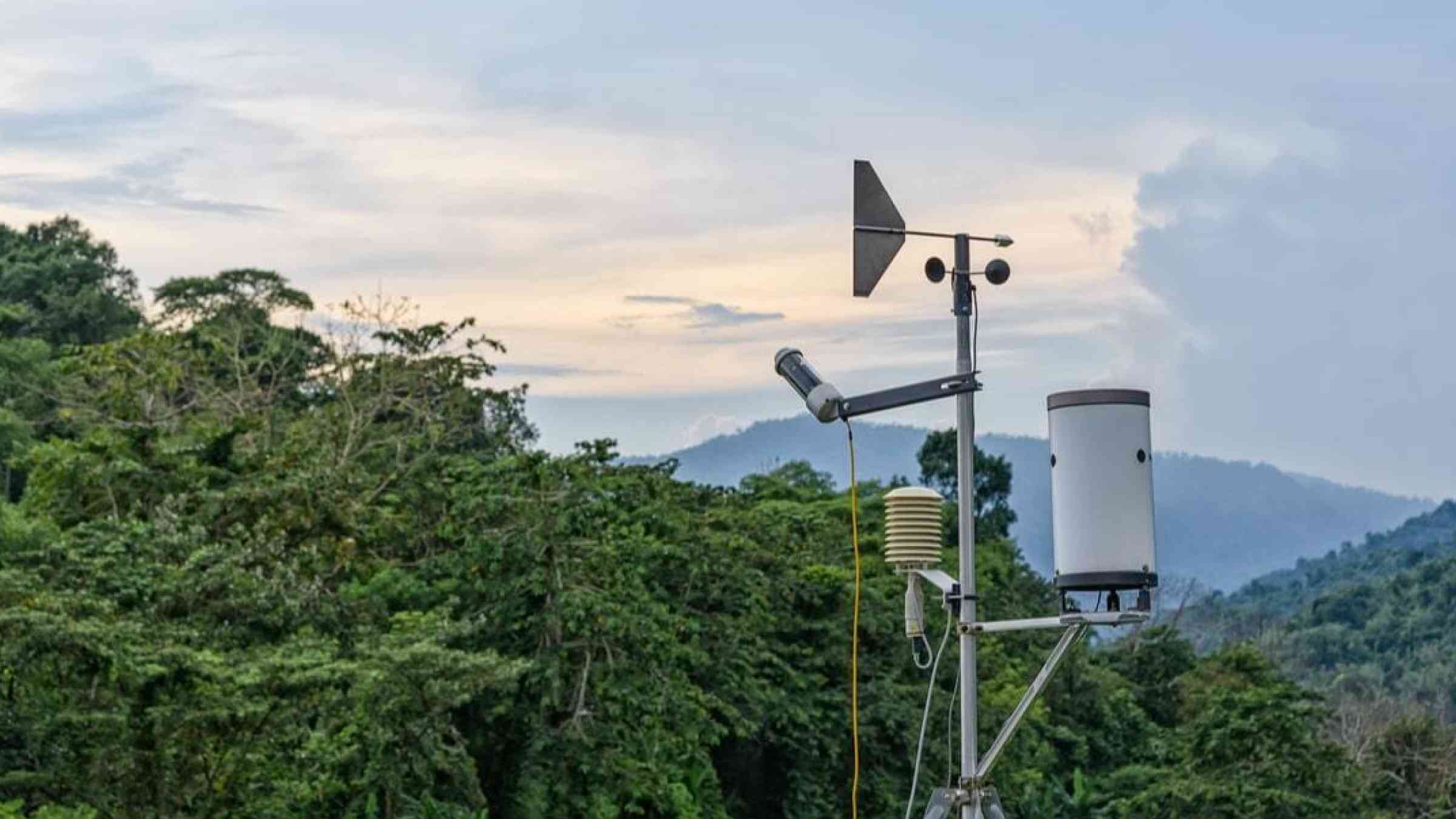 Weather monitoring station in tree-covered hilly surroundings