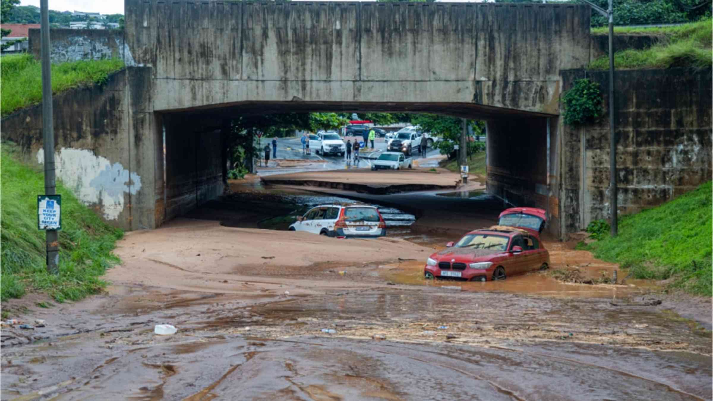 Cars are lying in mud beneath a bridge in Durban, South Africa, after the floods in April 2022.