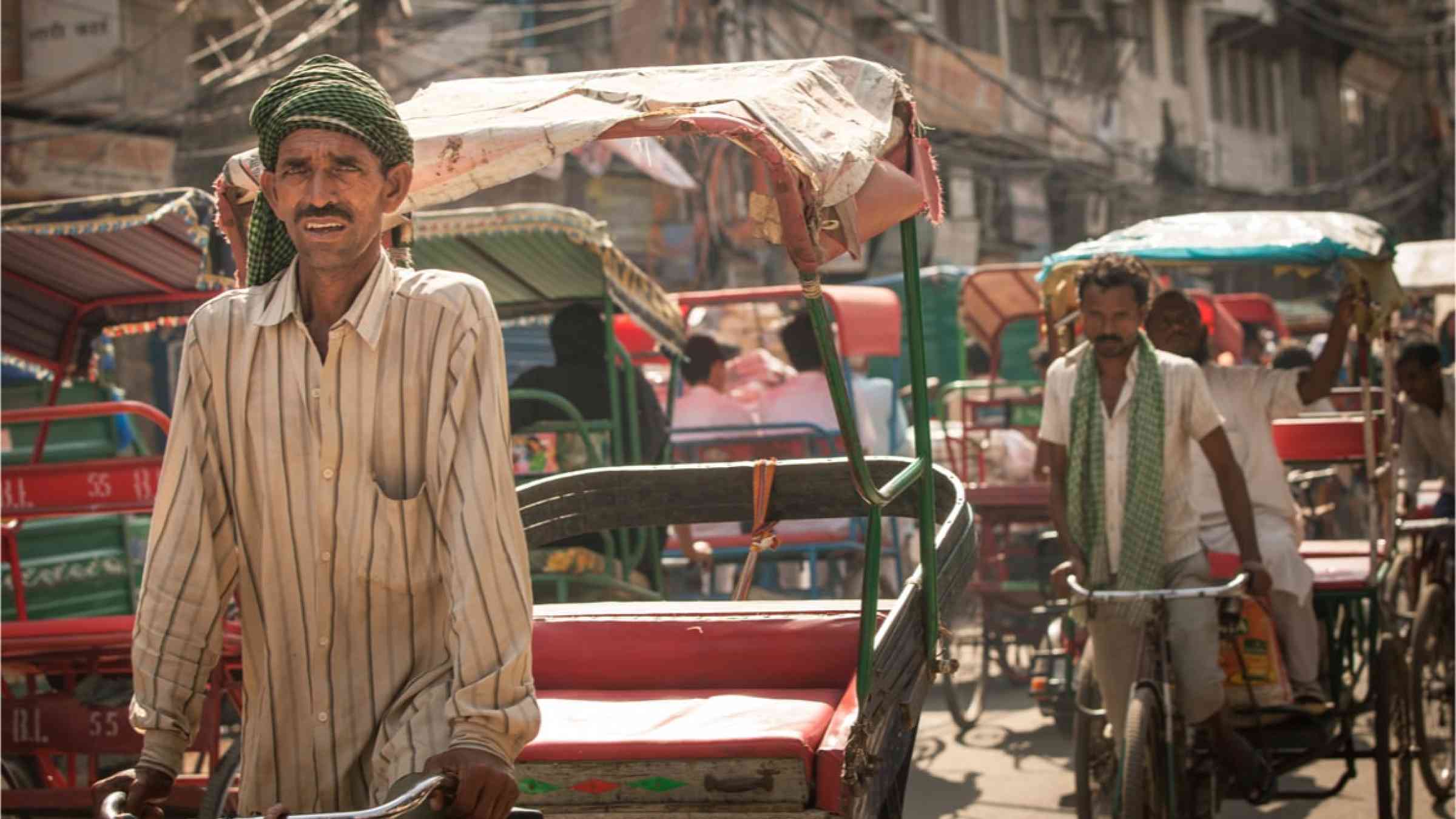 Two Rickshaw pullers in India on the hot streets.